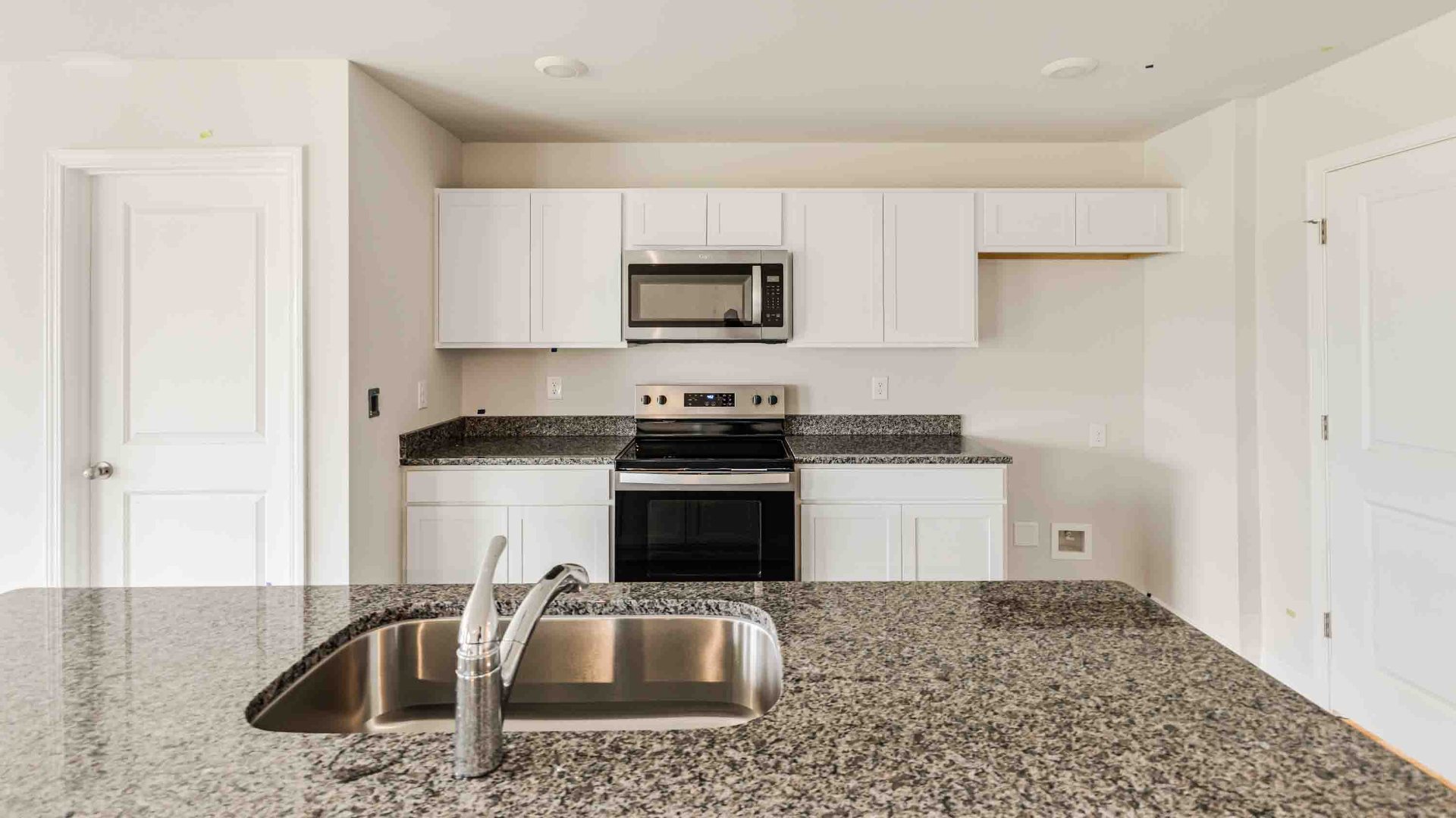 The kitchen features a large island, granite countertops, and stainless-steel appliances, which are sure to both turn heads and make meal prep easy. You’ll never be too far from the action with the living and dining area right there.