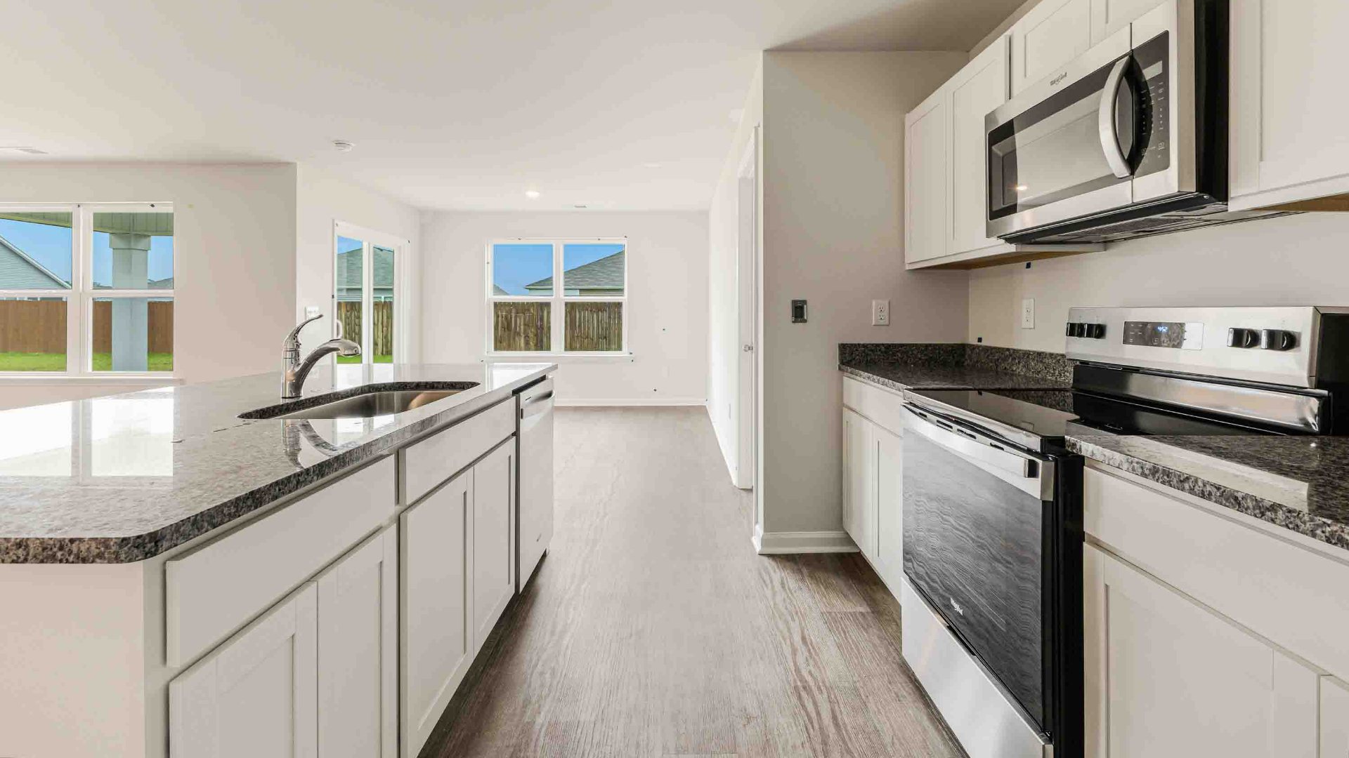 The kitchen features a large island, granite countertops, and stainless-steel appliances, which are sure to both turn heads and make meal prep easy. You’ll never be too far from the action with the living and dining area right there.