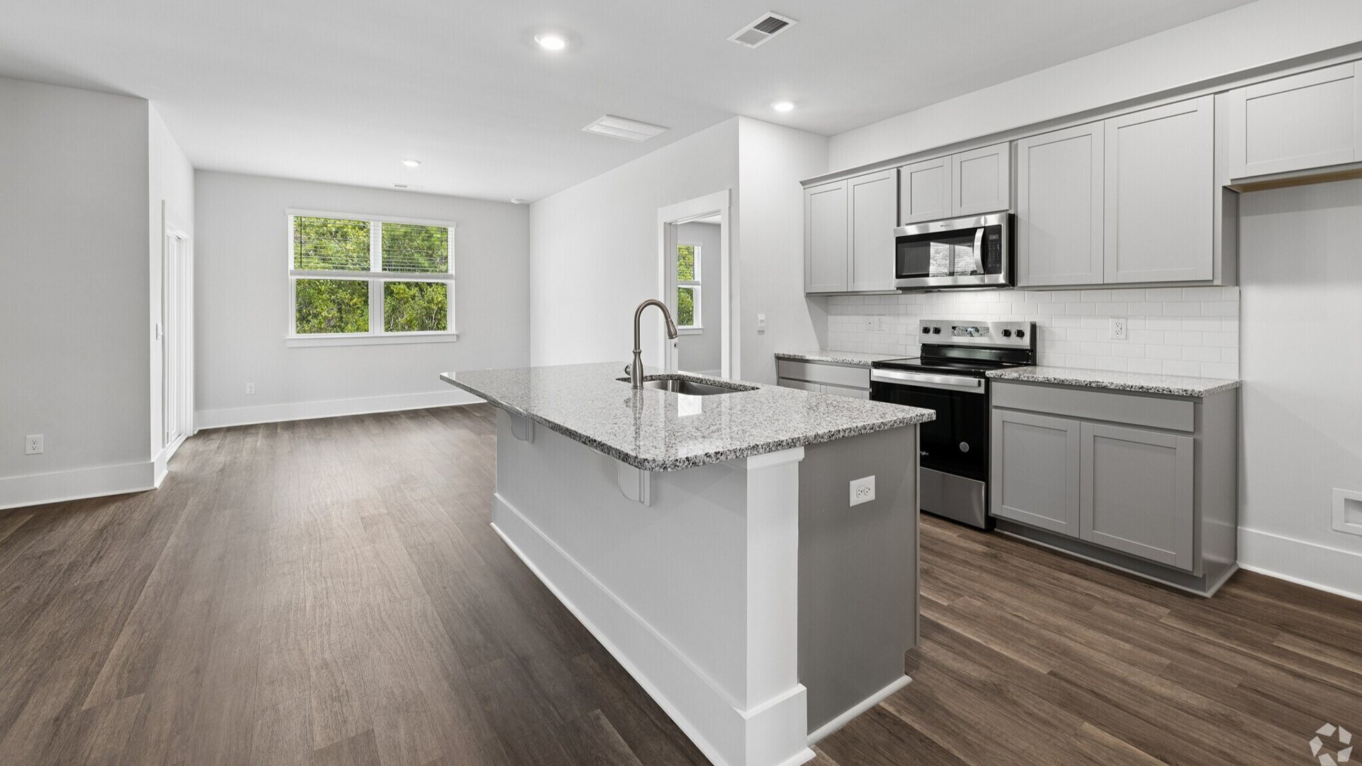 The kitchen features a large island, granite countertops, and stainless-steel appliances, which are sure to both turn heads and make meal prep easy.