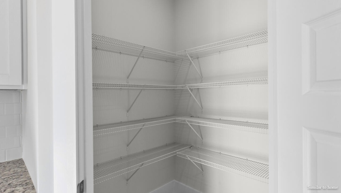 The kitchen boasts stainless steel appliances, a walk-in pantry, and a generous island that flows seamlessly into the main living area. D