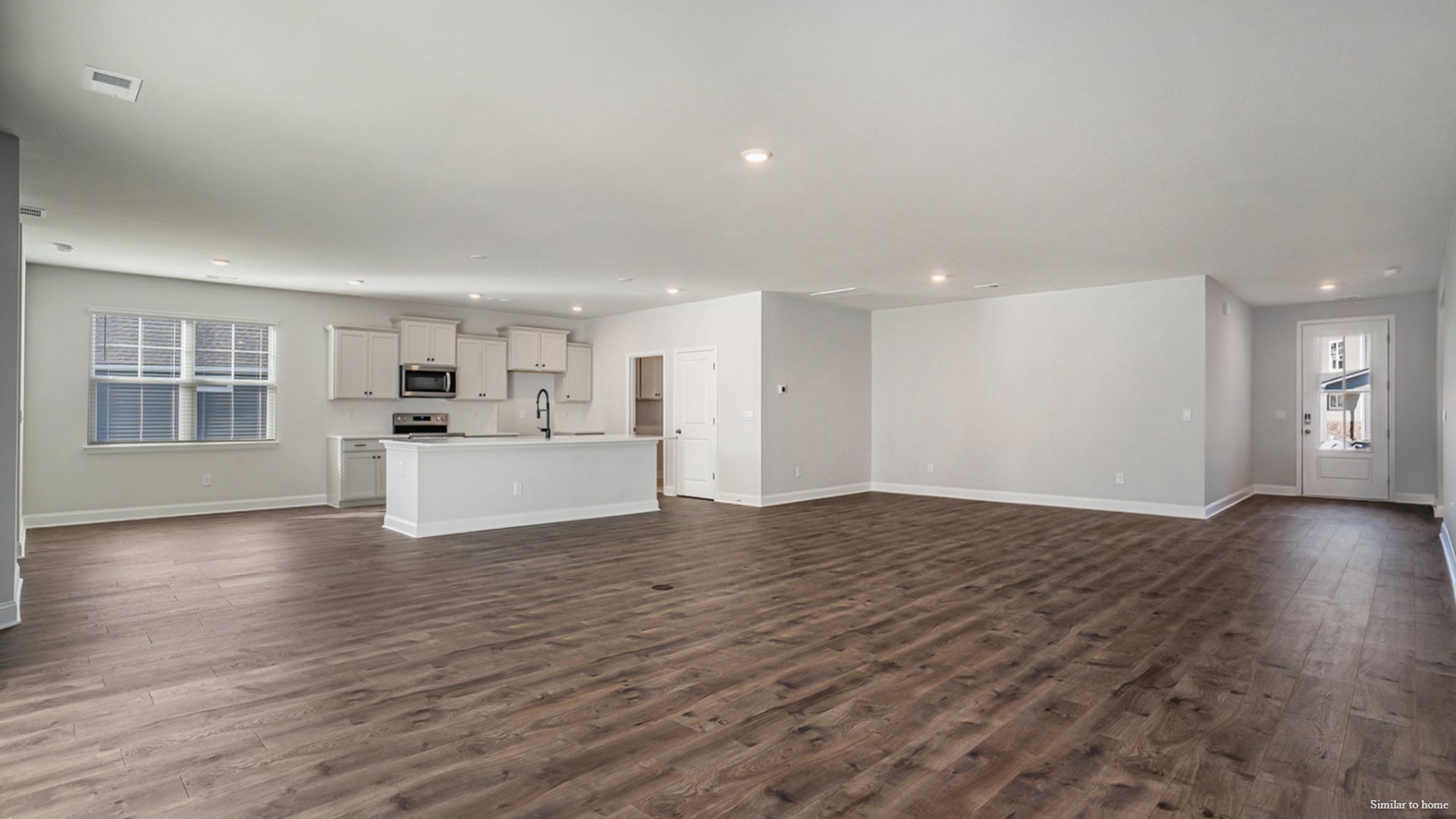 The kitchen features a central island and flows into a walk-in Pantry and a separate laundry room, which in turn connects to a storage area and the large three-car garage.