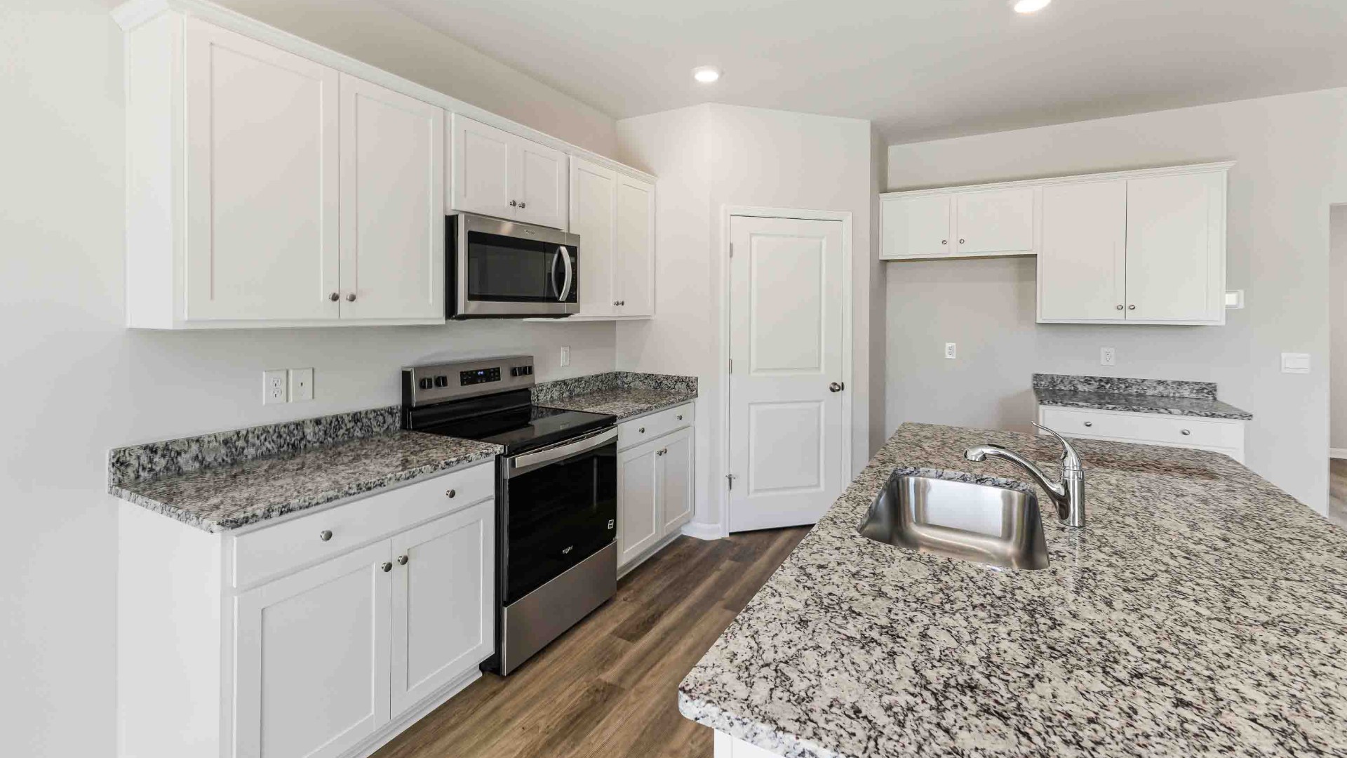 The open-concept kitchen features large kitchen island, walk-in pantry, granite countertops and stainless steel appliances. The kitchen seamlessly connects to the dining and living areas, creating a great space for entertainment.