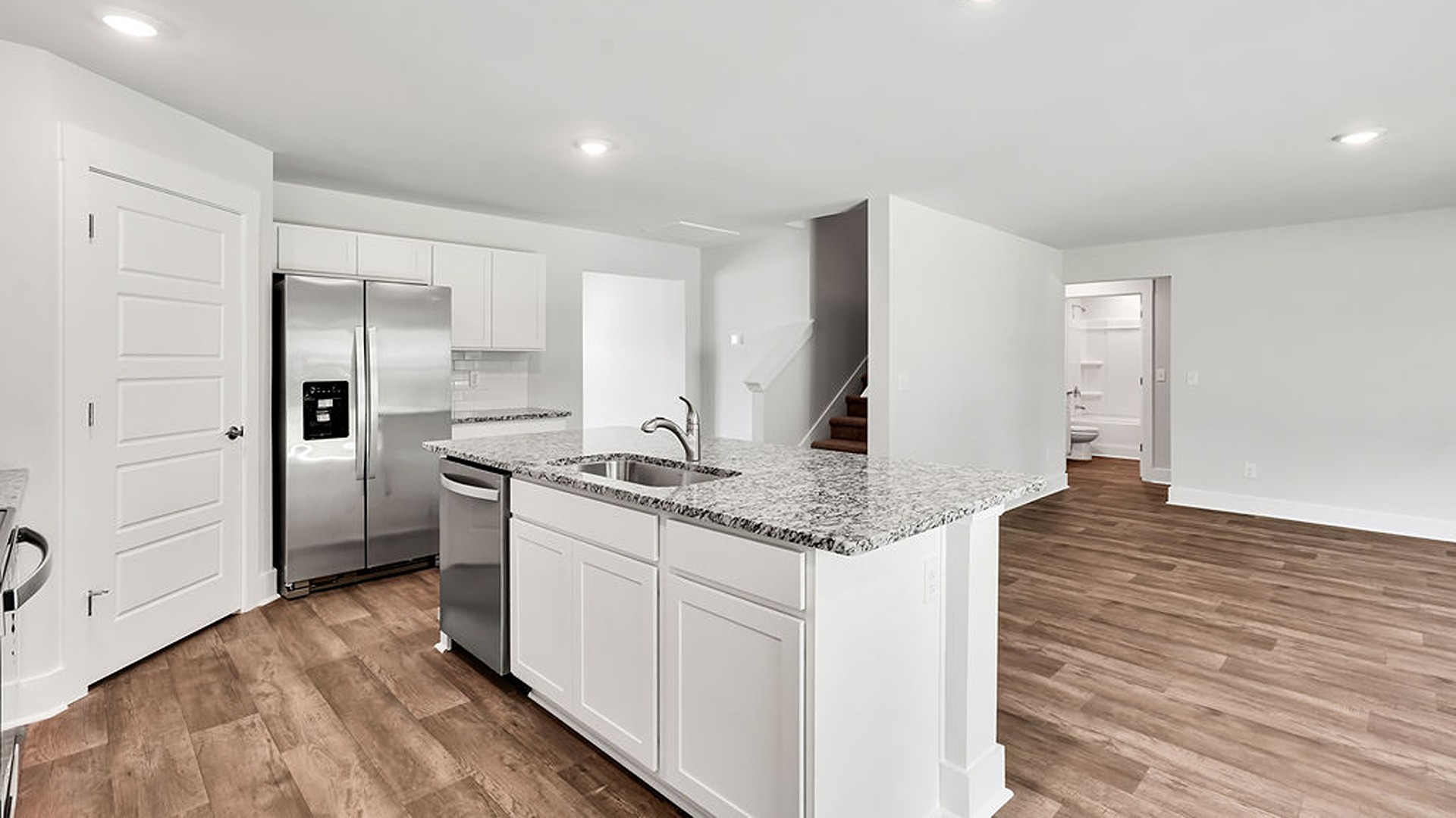 The open-concept kitchen features granite countertops and stainless-steel appliances. The kitchen seamlessly connects to the dining and living areas, creating a great space for entertainment.