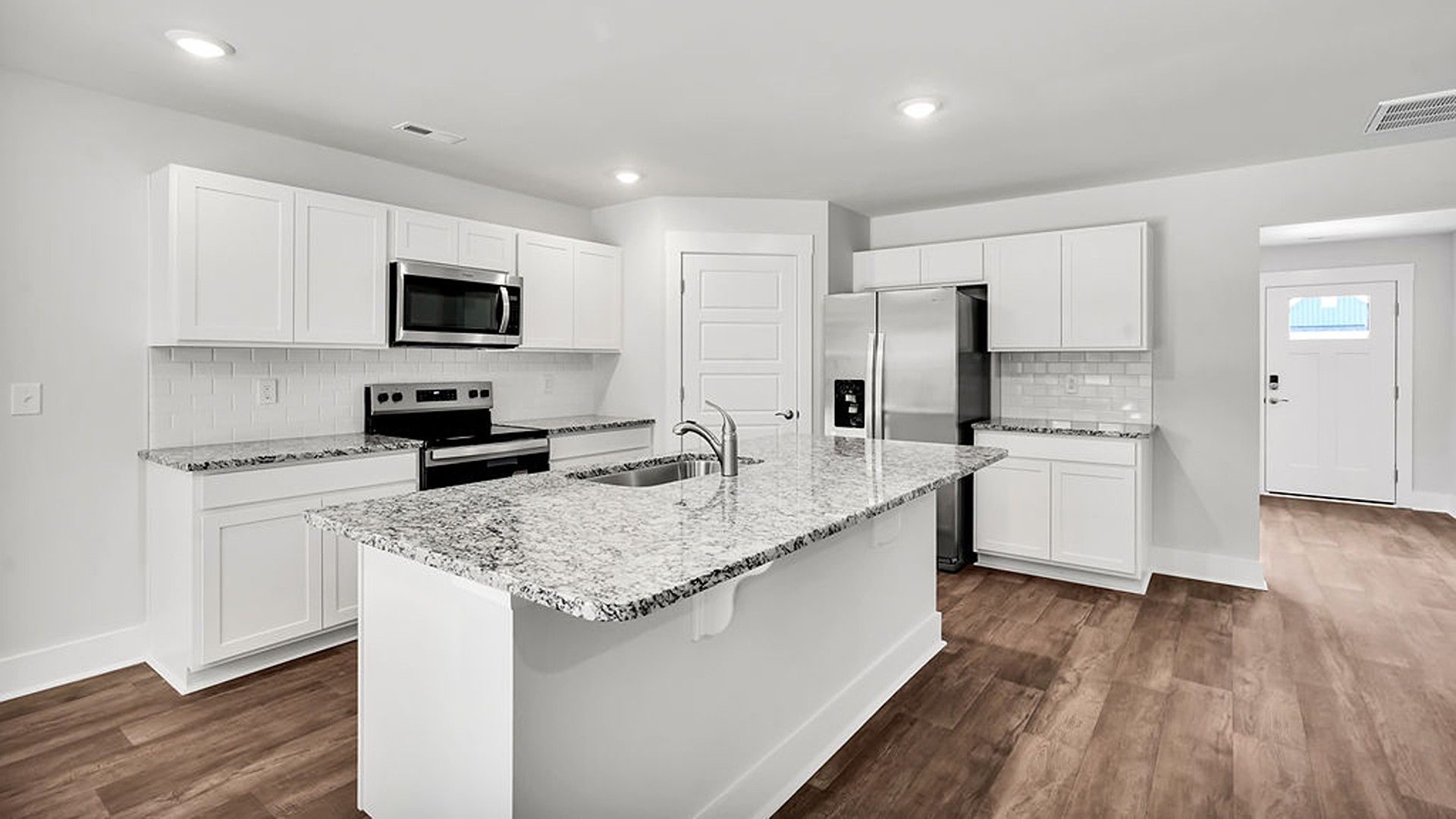 The open-concept kitchen features granite countertops and stainless-steel appliances. The kitchen seamlessly connects to the dining and living areas, creating a great space for entertainment.