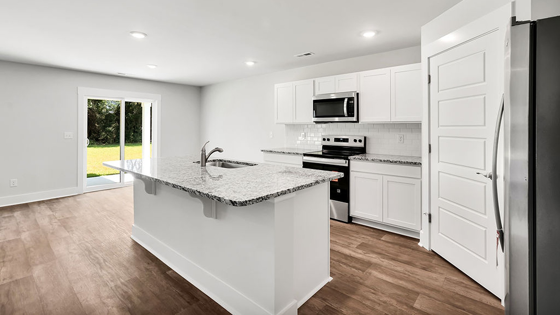 The open-concept kitchen features granite countertops and stainless-steel appliances. The kitchen seamlessly connects to the dining and living areas, creating a great space for entertainment.