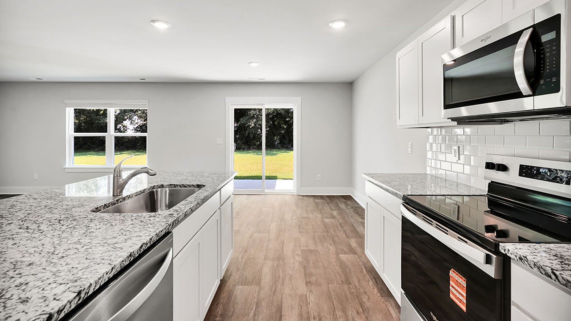 The open-concept kitchen features granite countertops and stainless-steel appliances. The kitchen seamlessly connects to the dining and living areas, creating a great space for entertainment.