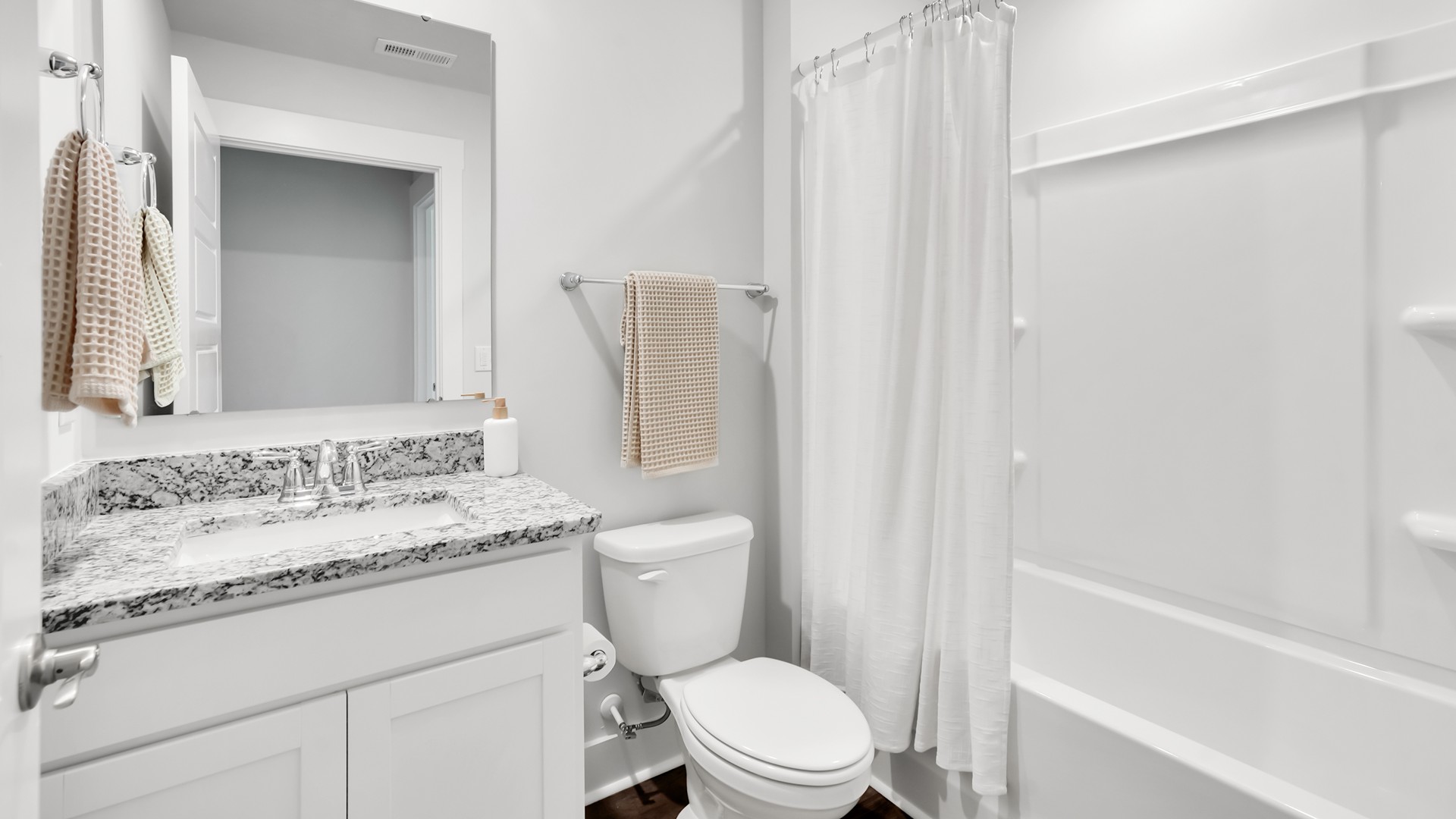 The Guilford second story provides a private living area separate from the main floor, which includes a large upstairs living room, the Primary Bedroom suite, and three additional bedrooms with shared access to bathrooms and laundry facilities. The flooring is a mix of carpet in the bedrooms and vinyl flooring in the laundry room and bathrooms. A full bathroom is conveniently accessible by all three secondary bedrooms.