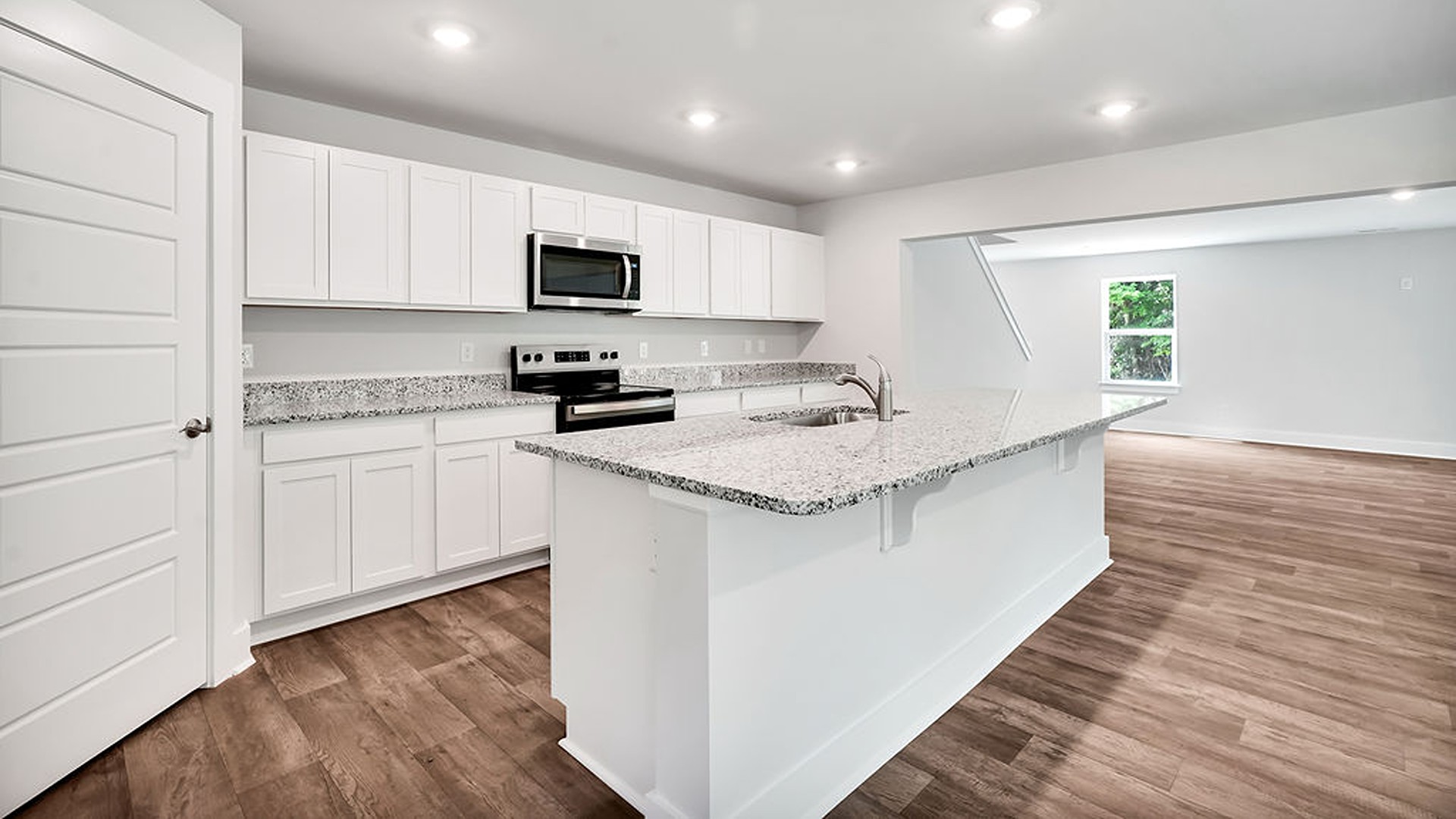The kitchen features a chef's island, stainless steel appliances, granite countertops, and a spacious walk-in pantry. The kitchen island is the perfect size for meal prep with a built-in sink and dishwasher