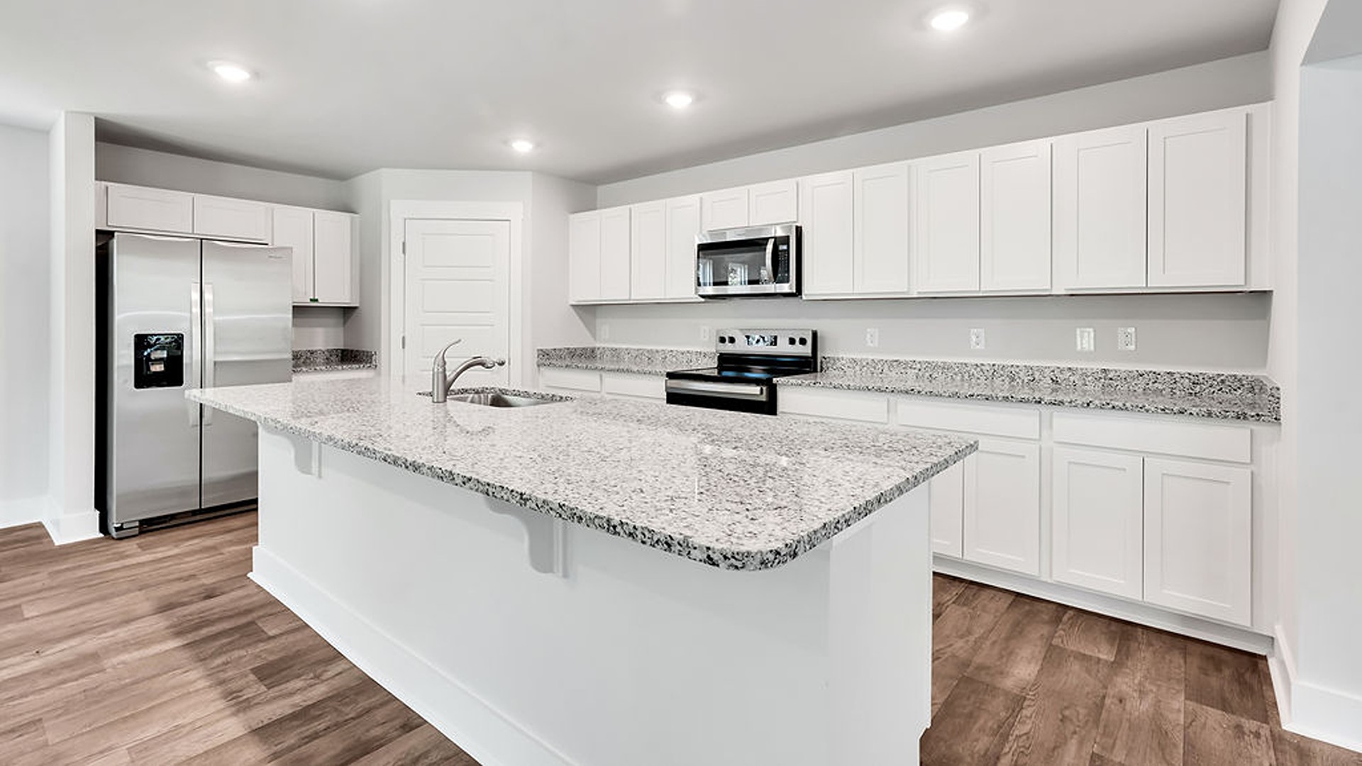 The kitchen features a chef's island, stainless steel appliances, granite countertops, and a spacious walk-in pantry. The kitchen island is the perfect size for meal prep with a built-in sink and dishwasher