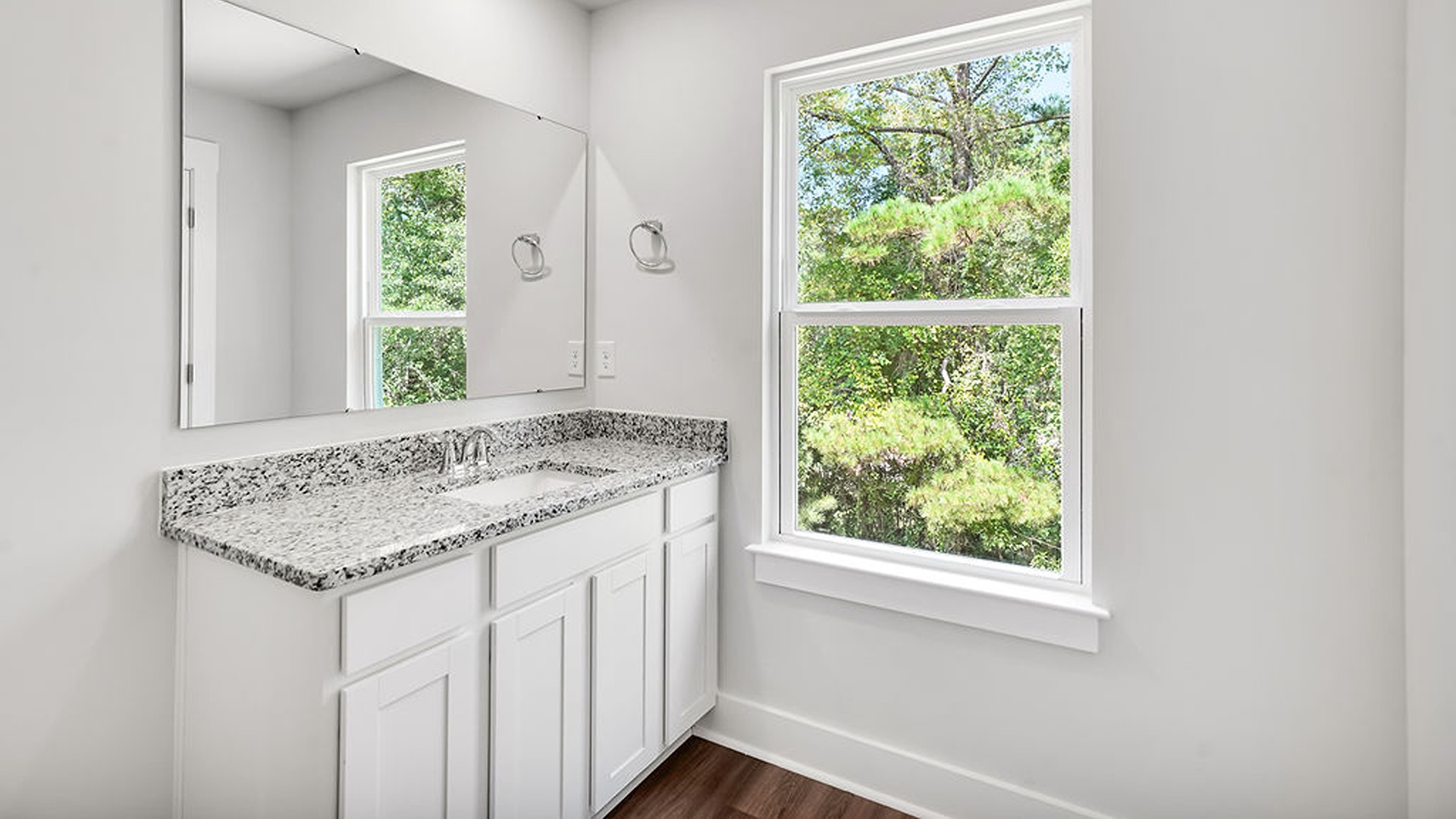 Adjacent to the entry area is Bedroom 2, a versatile space that can serve as a guest room or home office. It has access to a full bathroom situated next to the laundry room.