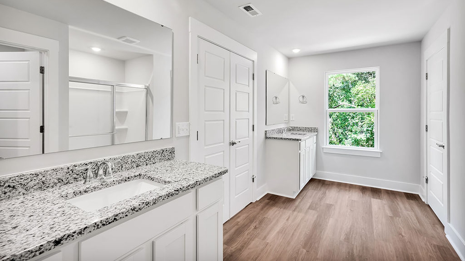 Adjacent to the entry area is Bedroom 2, a versatile space that can serve as a guest room or home office. It has access to a full bathroom situated next to the laundry room.