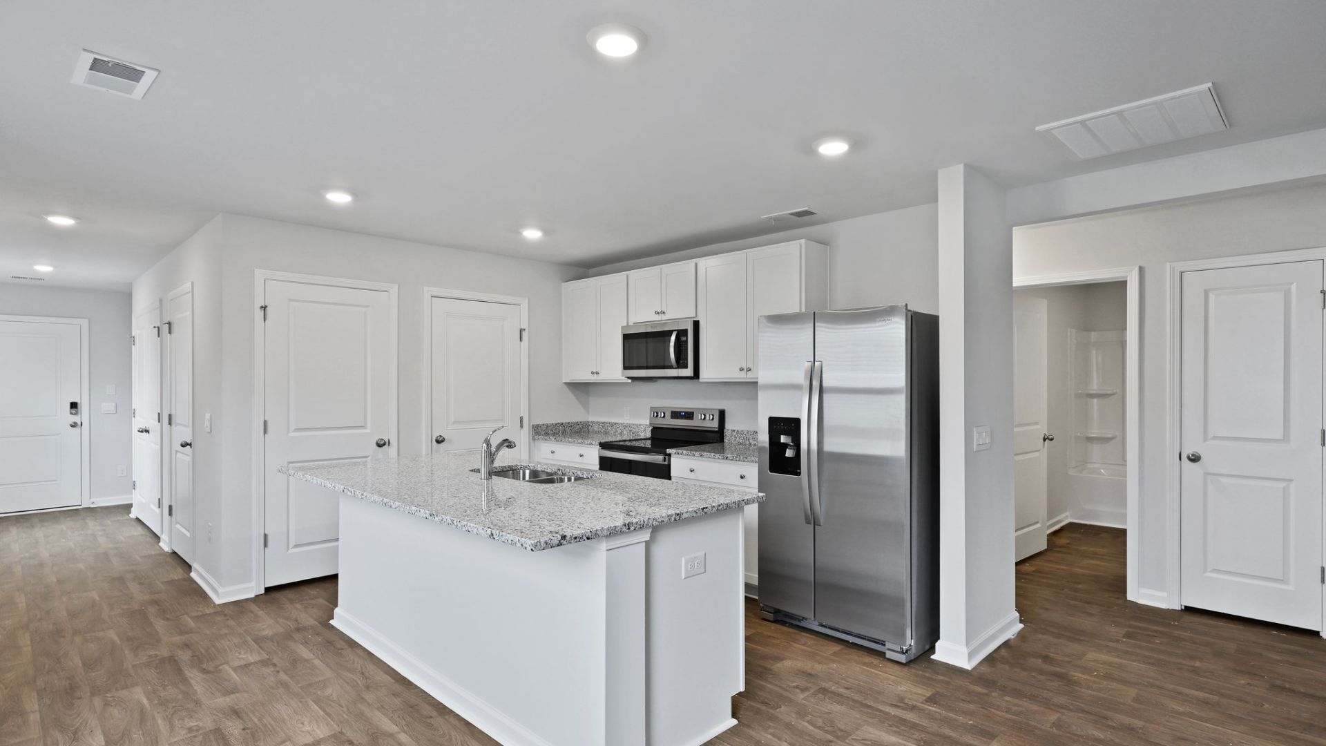 The kitchen features shaker-style cabinets, granite countertops, and stainless-steel appliances, which are sure to both turn heads and make meal prep easy. You’ll never be too far from the action with the living and dining area right there.