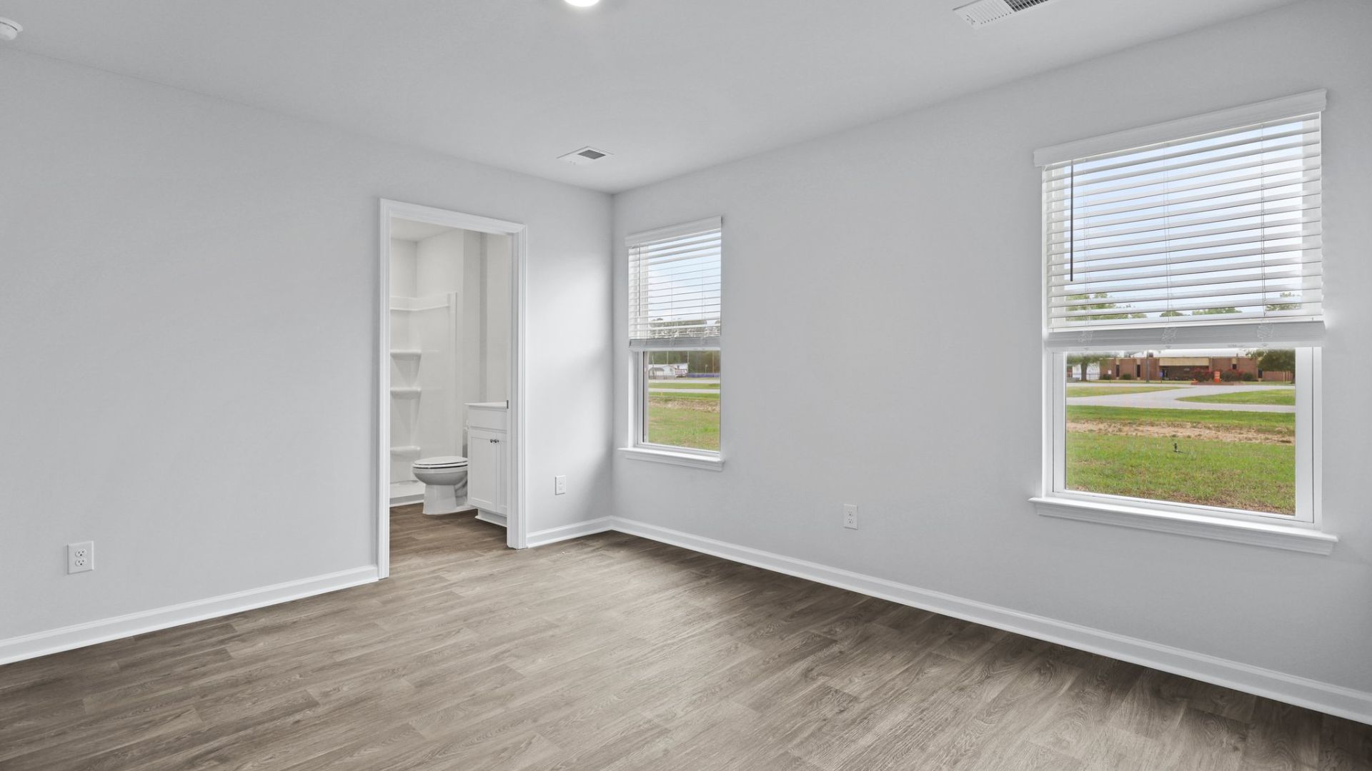Bedroom One, located at the back of the house for privacy, also has a suite bathroom with double vanity and walk-in closet. Two other bedrooms share a second bathroom.