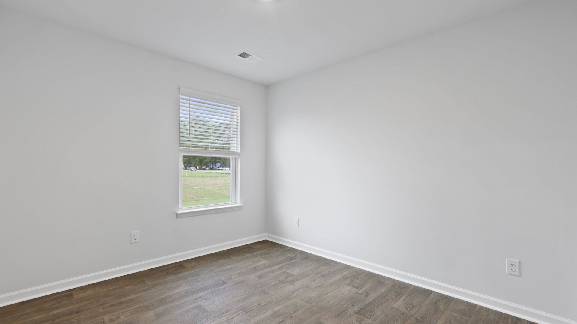 Two other bedrooms share a second bathroom. The laundry room is located at the front of home near the two-car garage, quietly away from living areas and bedrooms. Small covered porch at the front.