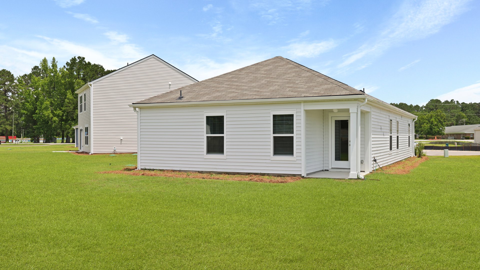 Two other bedrooms share a second bathroom. The laundry room is located at the front of home near the two-car garage, quietly away from living areas and bedrooms. Small covered porch at the front.