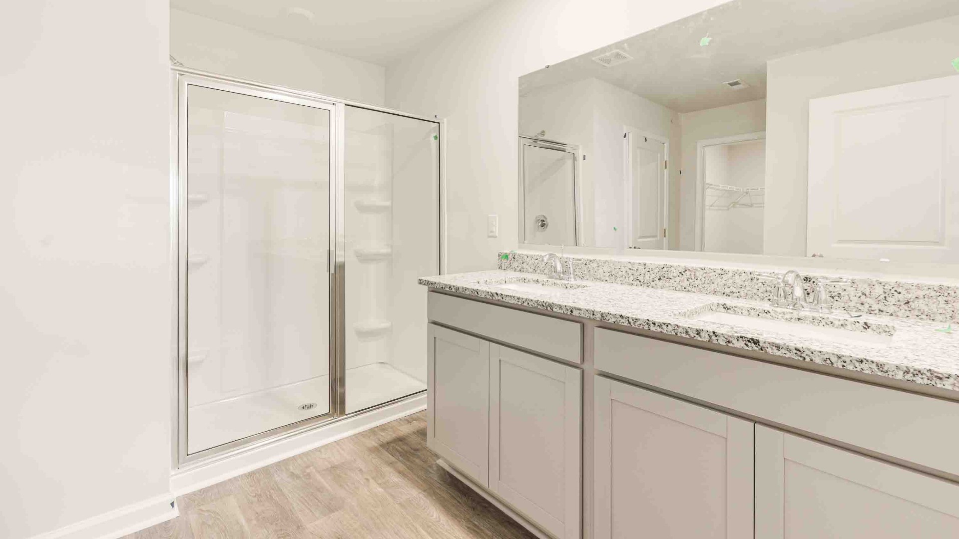 The primary suite is tucked away in the back of the home, offering a peaceful retreat complete with a walk-in shower (glass door included!), granite vanity, and a roomy walk-in closet.