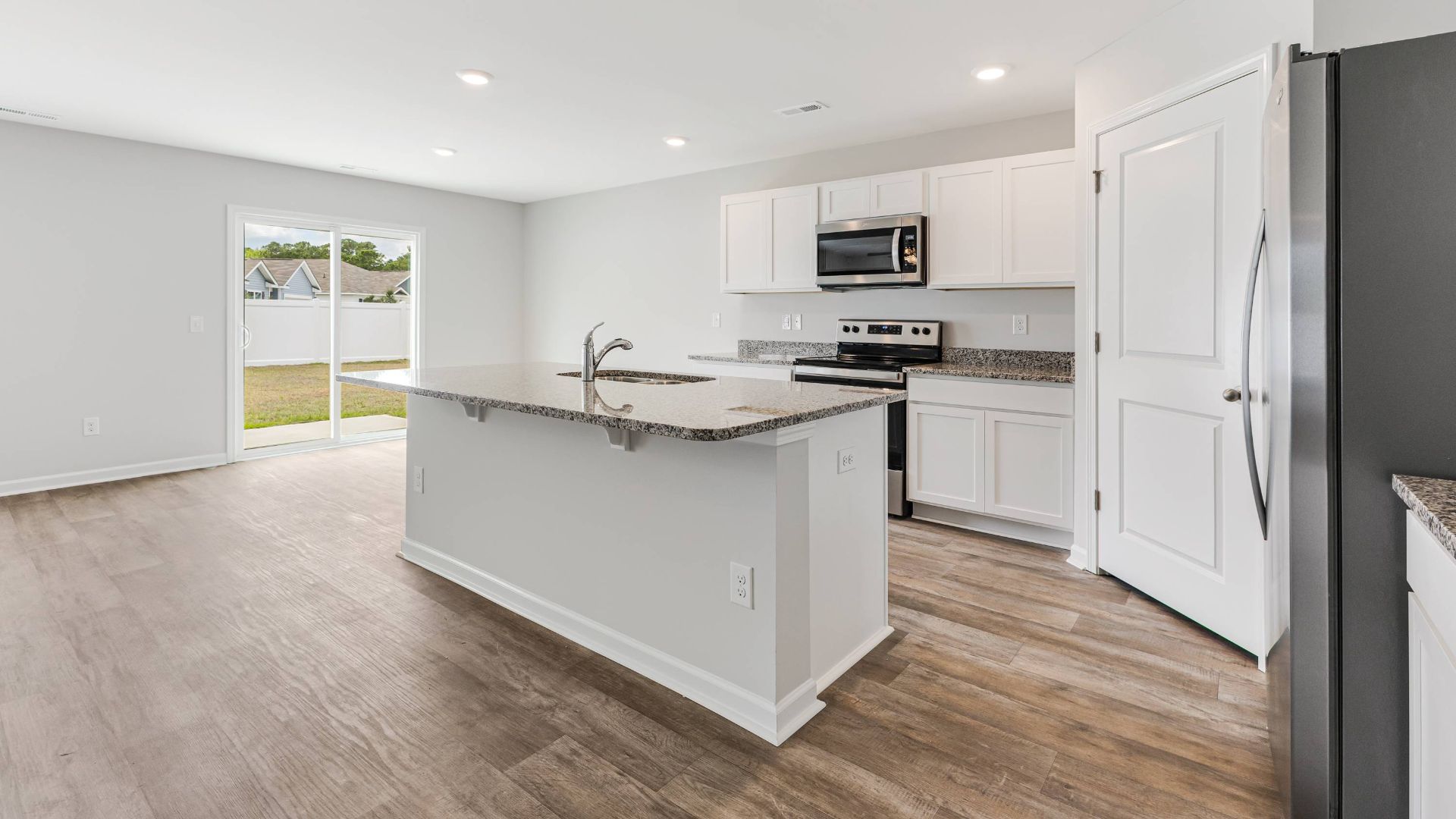 The kitchen features beautiful cabinets, granite countertops, and stainless steel appliances, which are sure to both turn heads and make meal prep easy. You’ll never be too far from the action with the living and dining area right there.