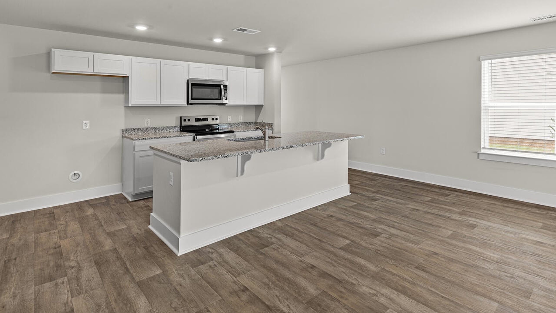 The kitchen features beautiful cabinets, granite countertops, and stainless steel appliances, which are sure to both turn heads and make meal prep easy. You’ll never be too far from the action with the living and dining area right there.