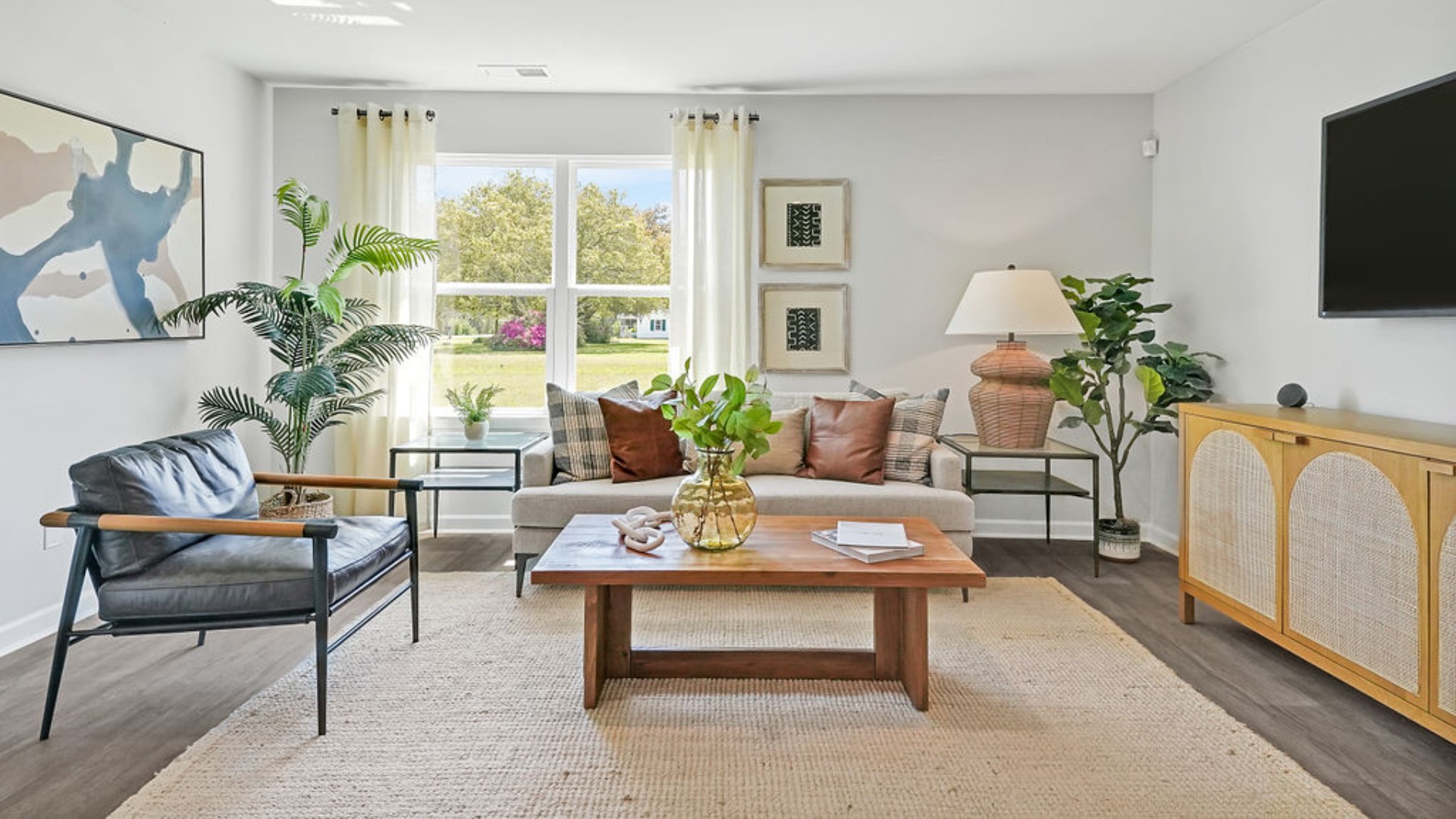 The open-concept family room, kitchen, and dining area feature stainless steel appliances, including a smooth-top range, dishwasher, and overhead microwave.