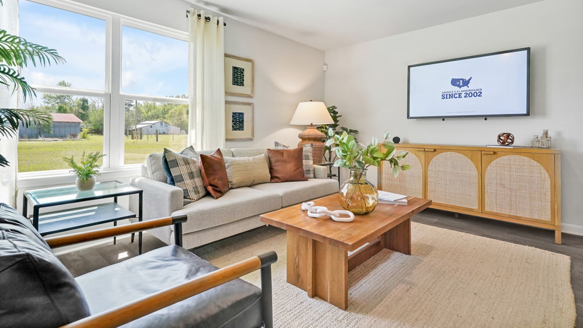 The open-concept family room, kitchen, and dining area feature stainless steel appliances, including a smooth-top range, dishwasher, and overhead microwave.