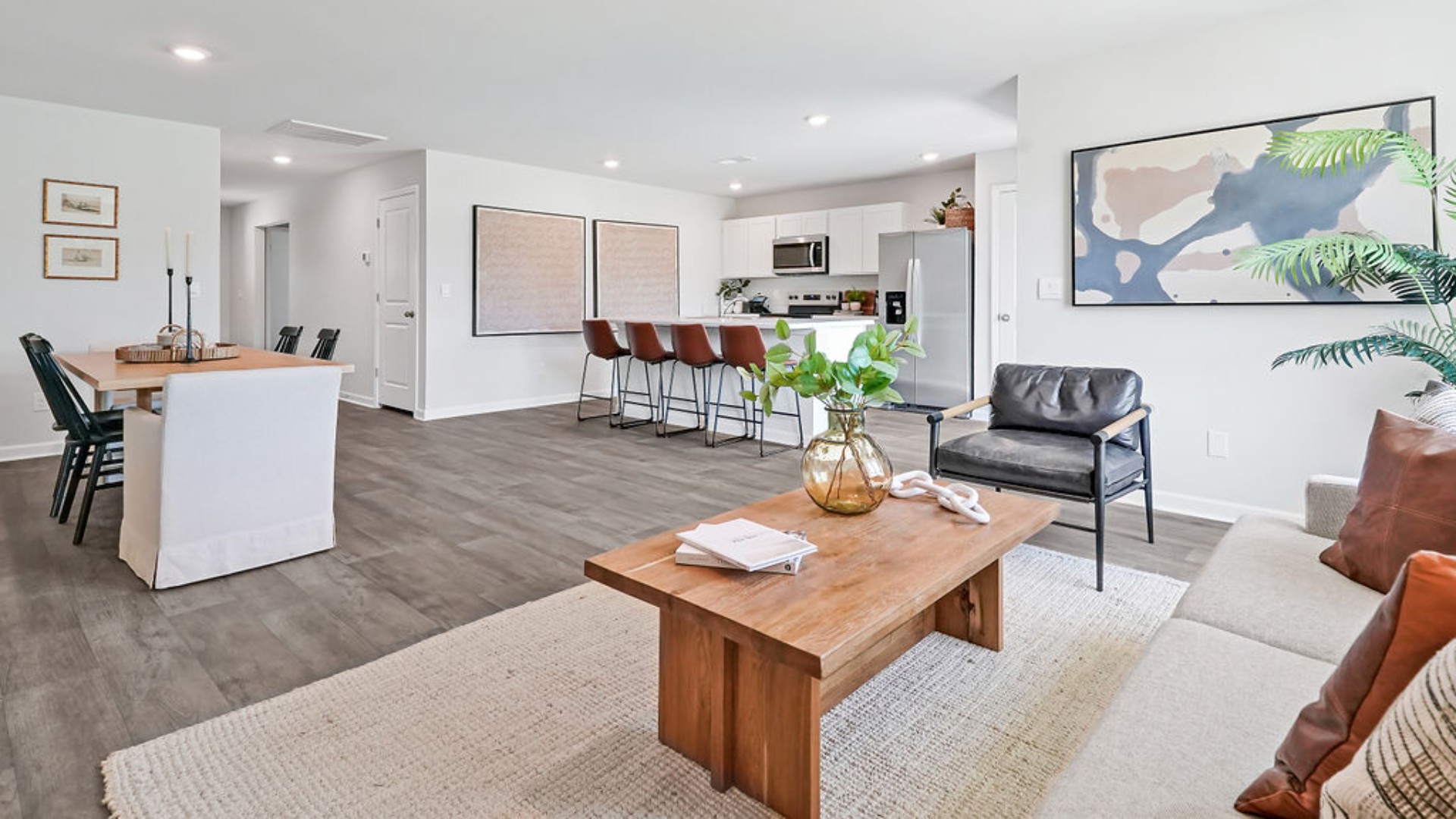 The open-concept family room, kitchen, and dining area feature stainless steel appliances, including a smooth-top range, dishwasher, and overhead microwave.