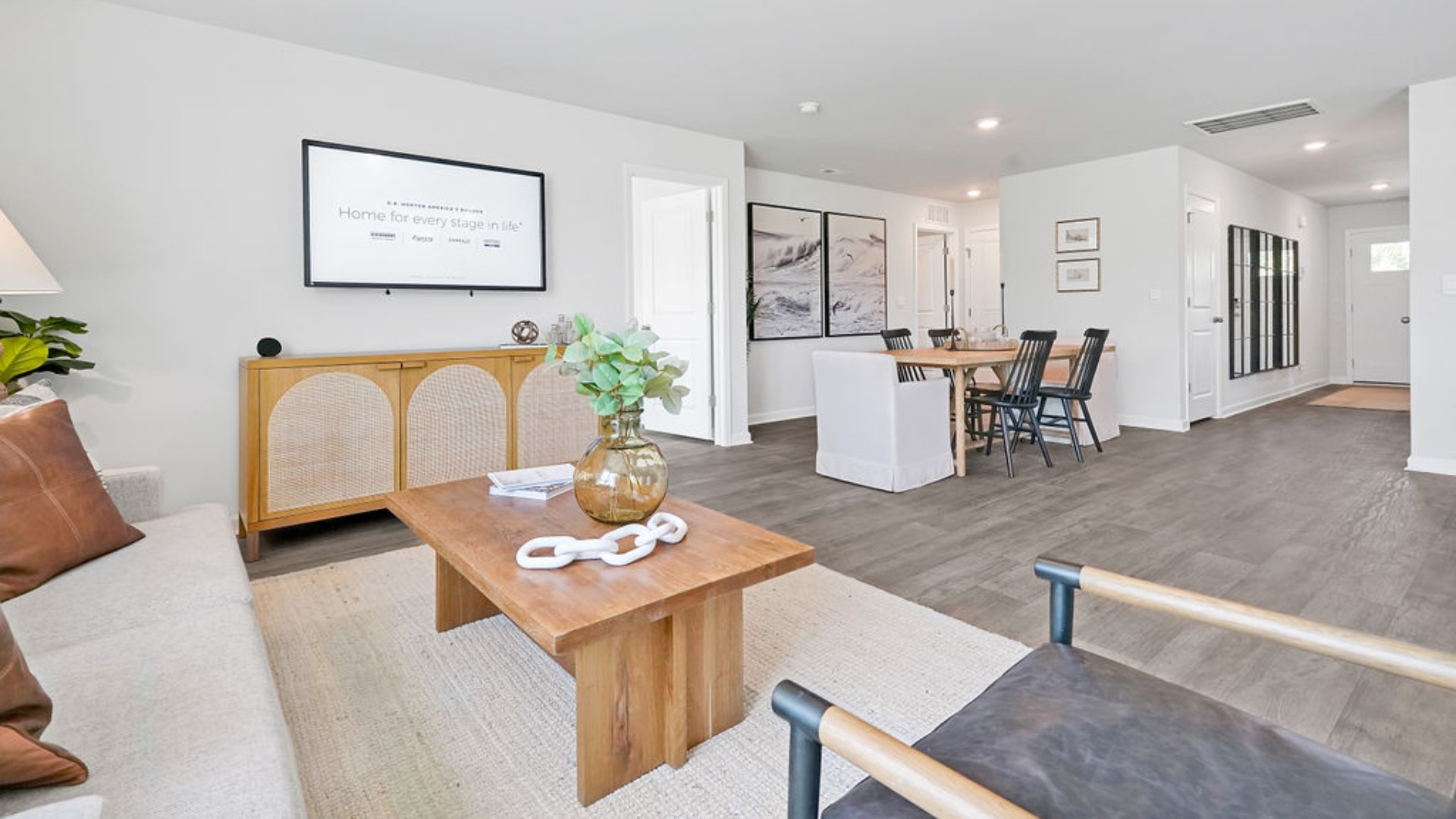 . The open-concept family room, kitchen, and dining area feature stainless steel appliances, including a smooth-top range, dishwasher, and overhead microwave.