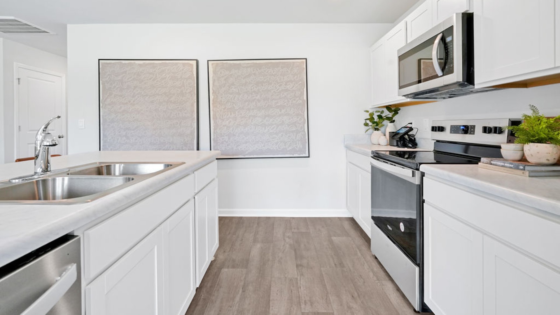 The open-concept family room, kitchen, and dining area feature stainless steel appliances, including a smooth-top range, dishwasher, and overhead microwave