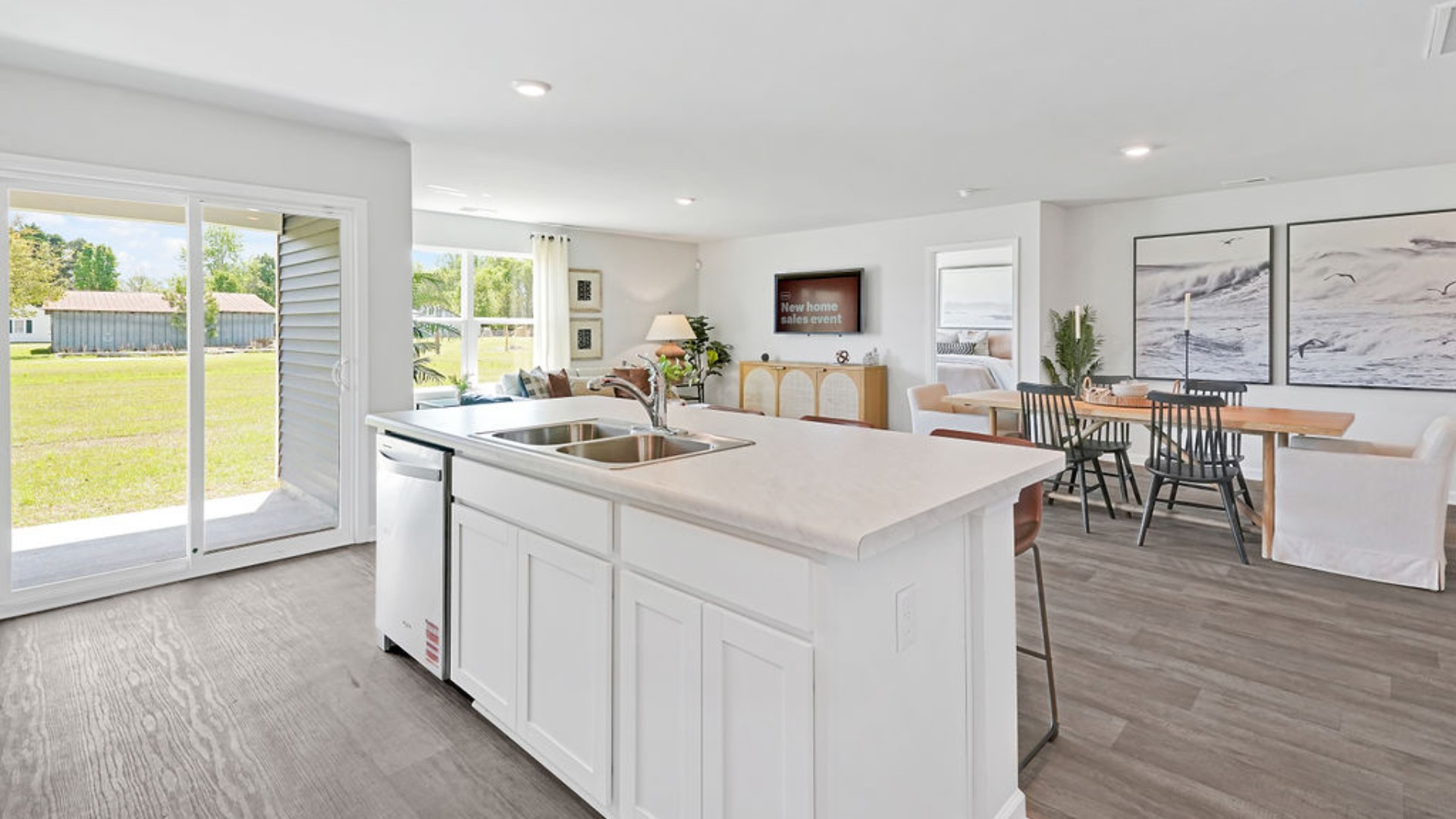 The open-concept family room, kitchen, and dining area feature stainless steel appliances, including a smooth-top range, dishwasher, and overhead microwave.
