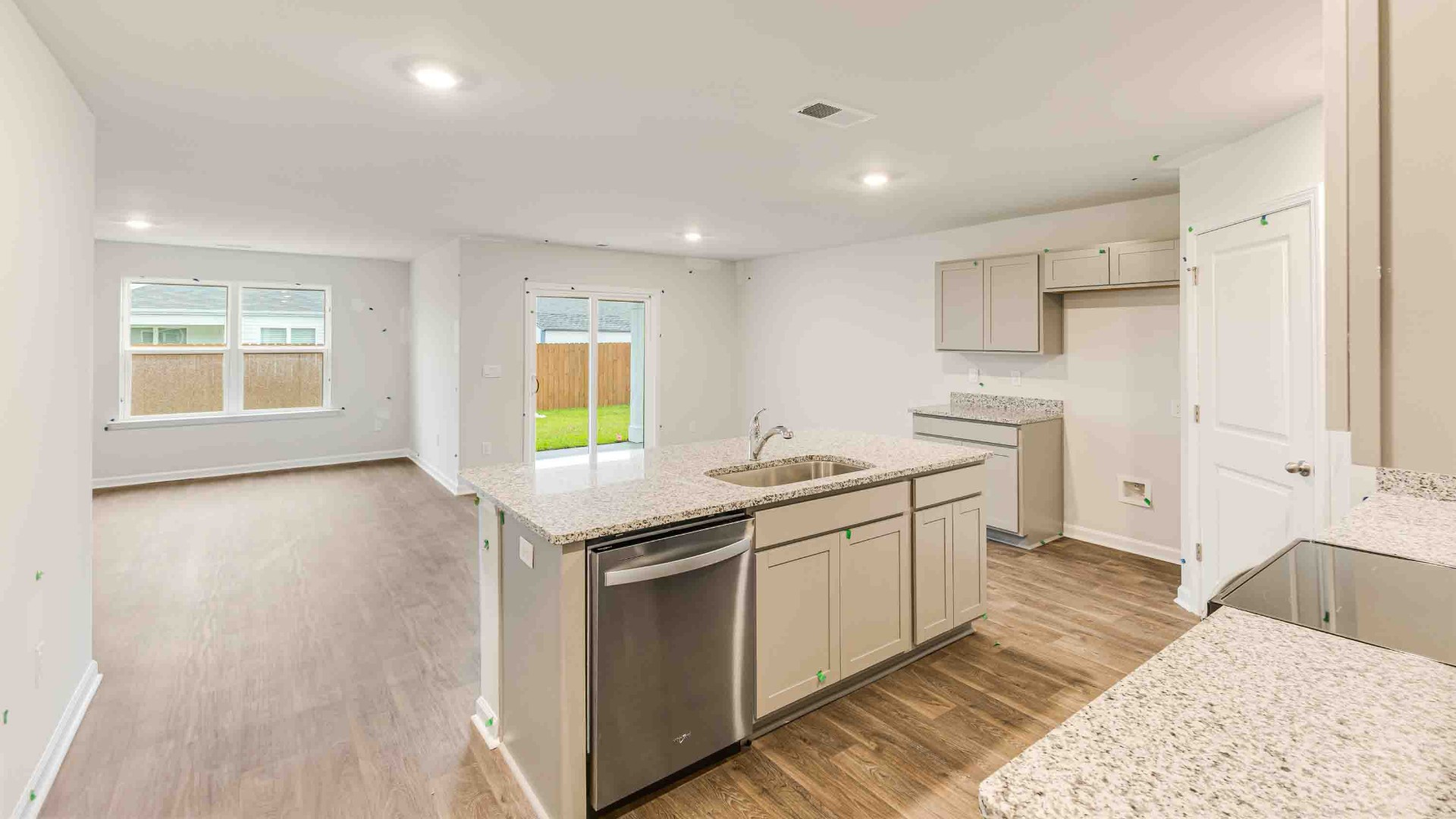The kitchen features a large island, laminate countertops, and stainless steel appliances, which are sure to both turn heads and make meal prep easy