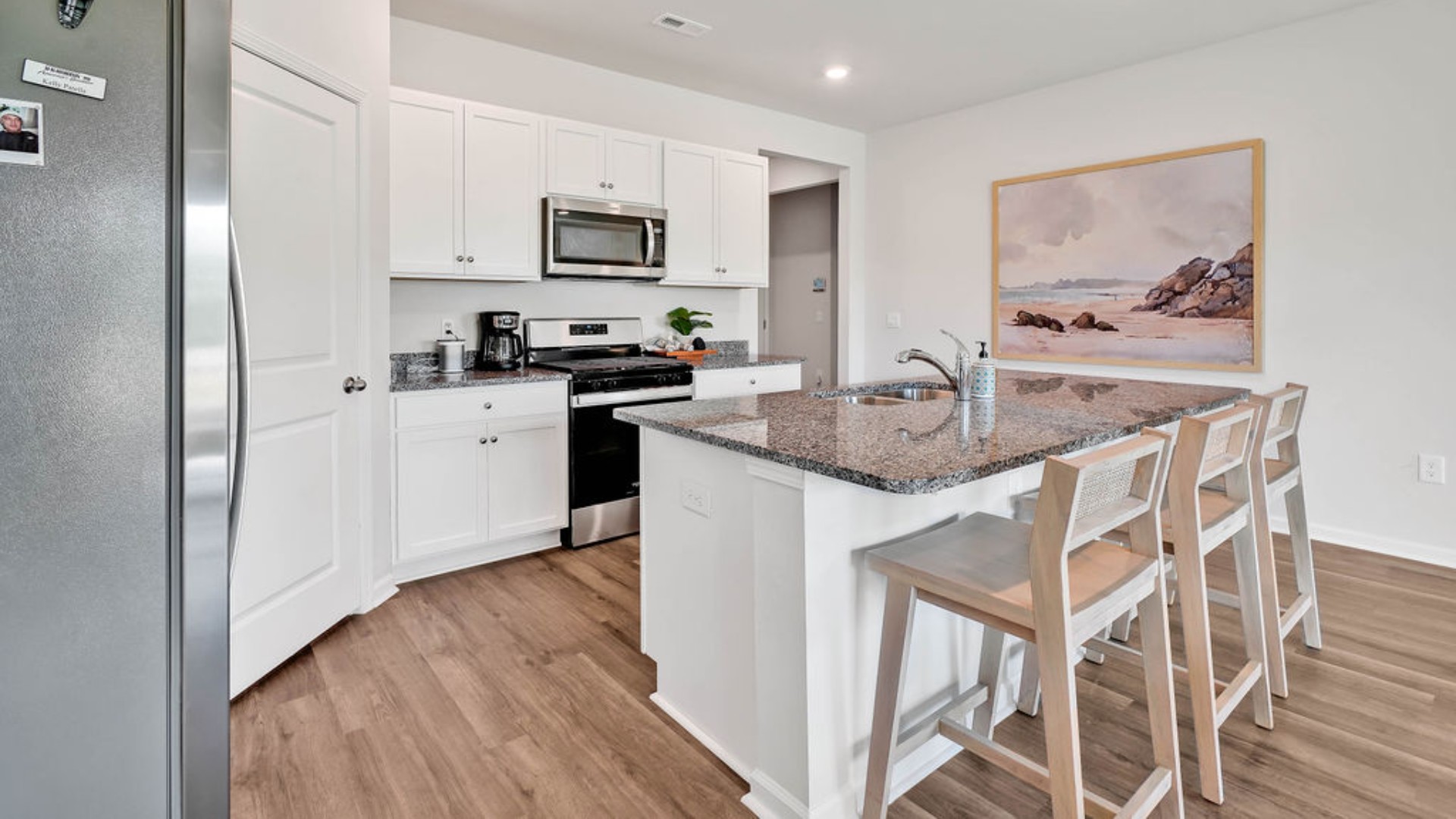 The kitchen features a large island, laminate countertops, and stainless steel appliances, which are sure to both turn heads and make meal prep easy. You’ll never be too far from the action with the living and dining area right there.