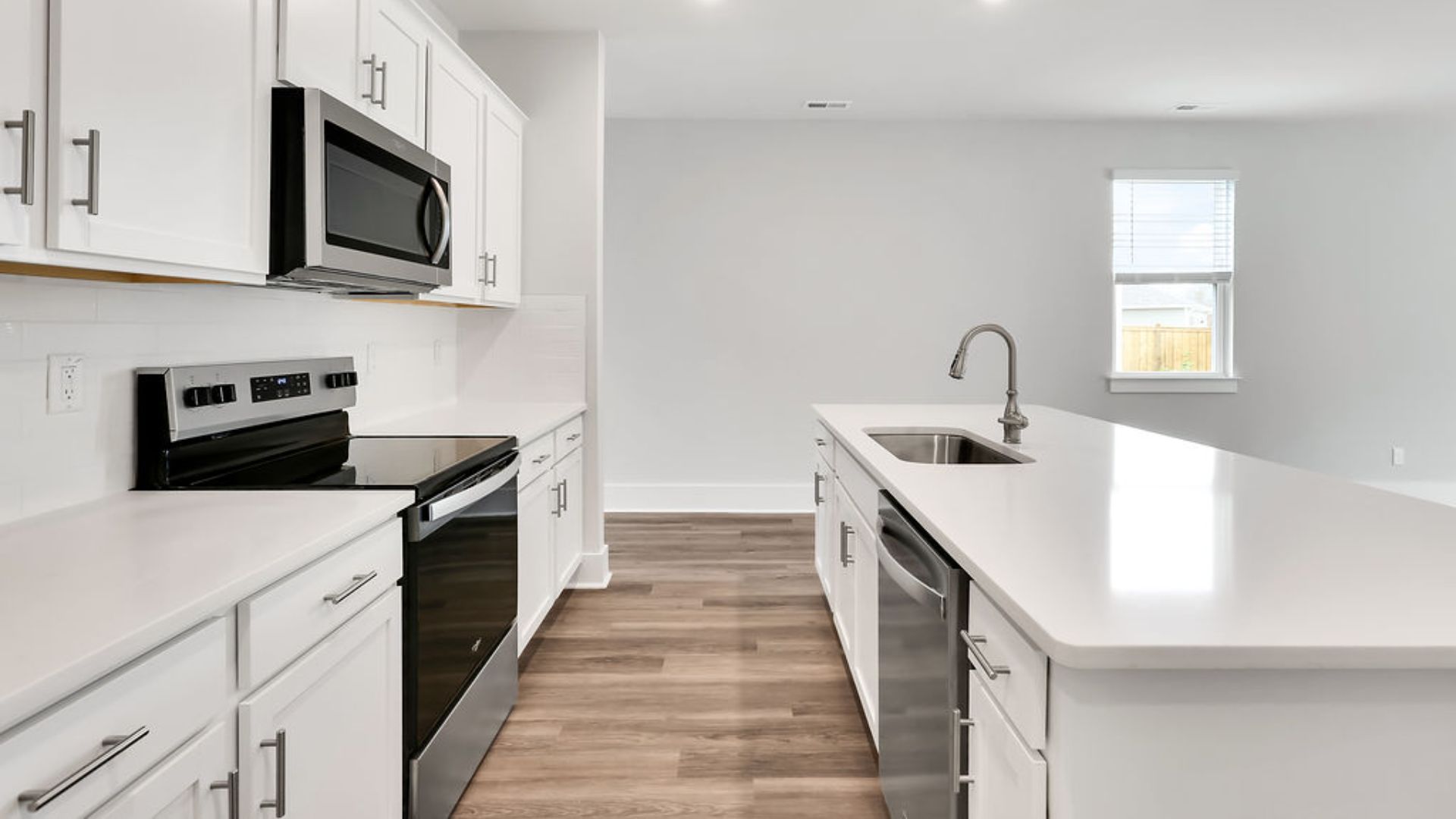 This beautiful kitchen features white cabinetry, granite counters, a large kitchen island with room for 4 counter height barstools and there's a pantry too. You’ll never be too far from the action with the living and dining area right there.