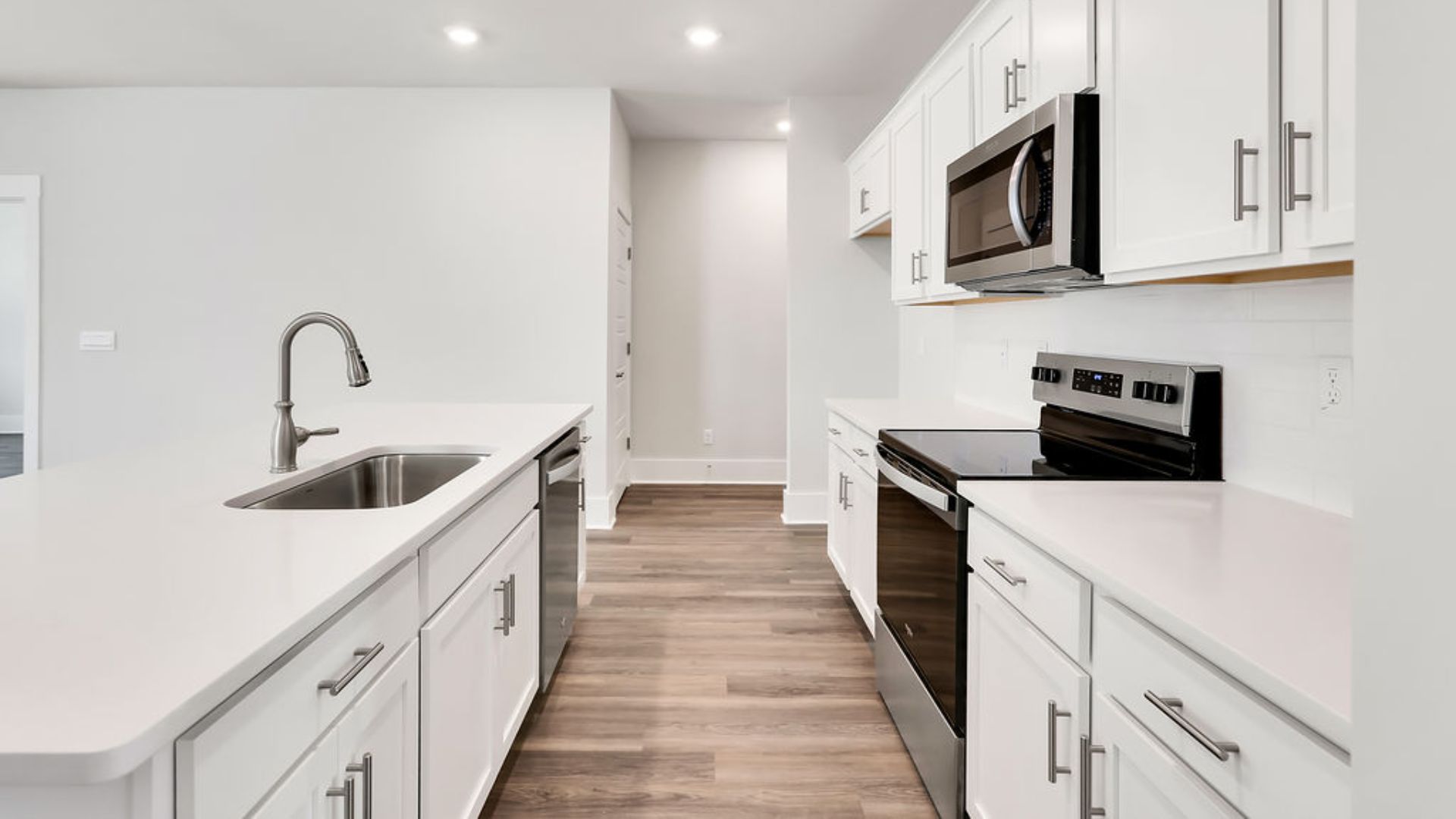 This beautiful kitchen features white cabinetry, granite counters, a large kitchen island with room for 4 counter height barstools and there's a pantry too. You’ll never be too far from the action with the living and dining area right there.