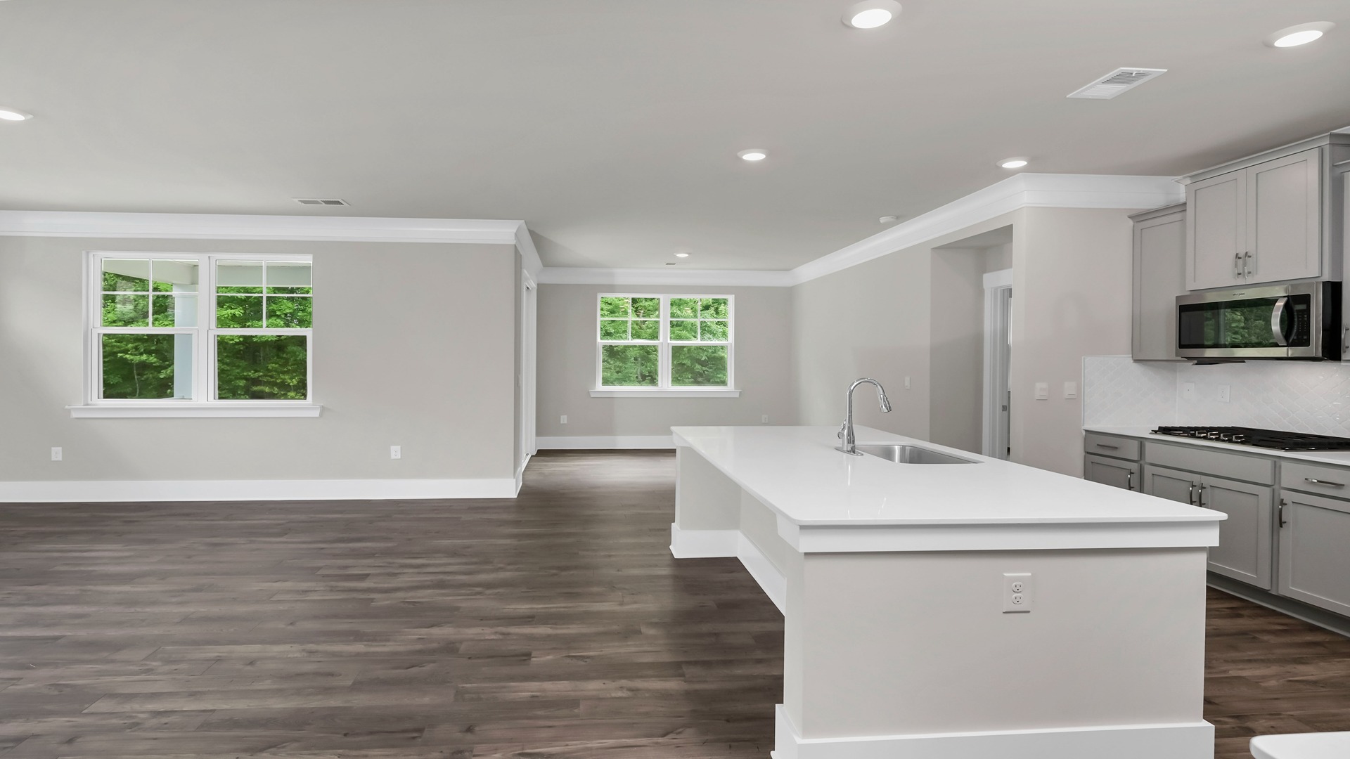 The ktichen, dining, and living areas are open concept finished with Revwood flooring.