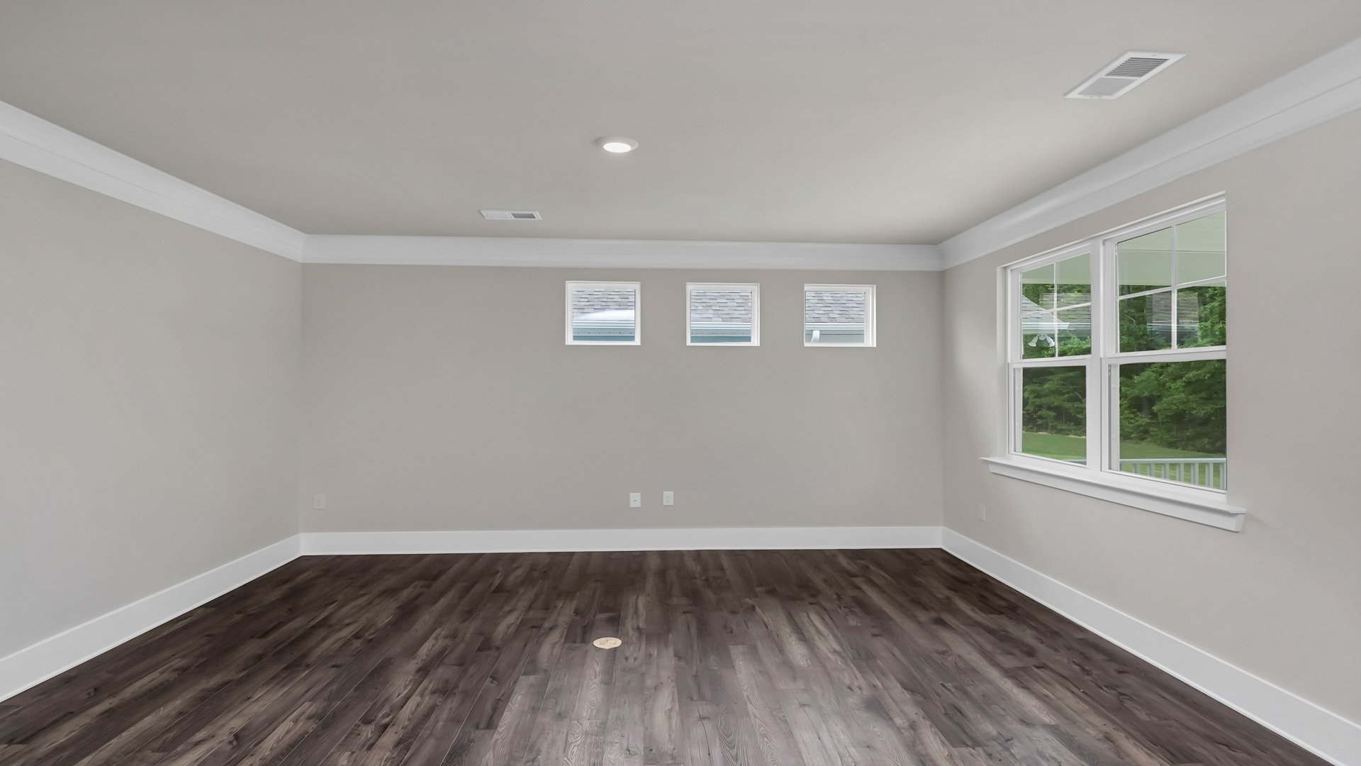 The living area features several windows for light and luxury vinyl flooring.