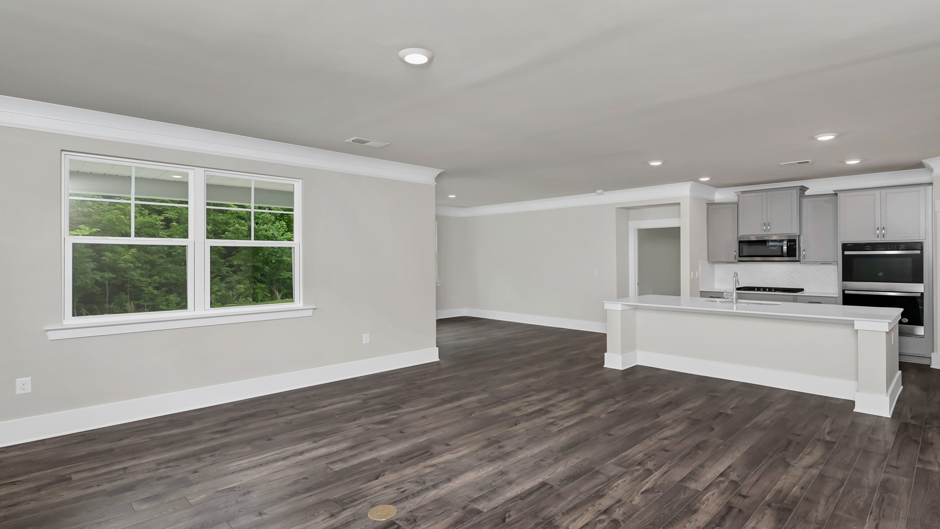 The ktichen, dining, and living areas are open concept finished with Revwood flooring.