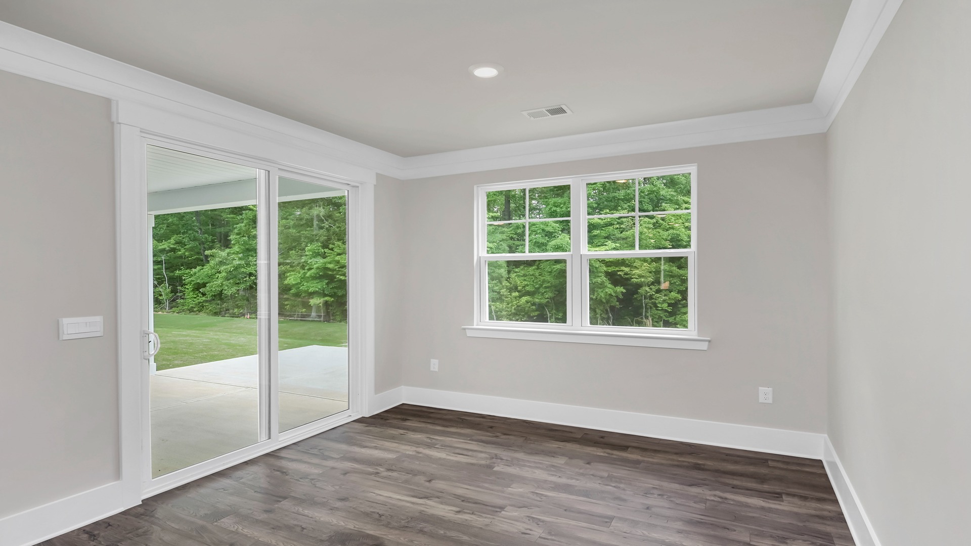 The dining area features ample natural light from back sliding doors and a large window.