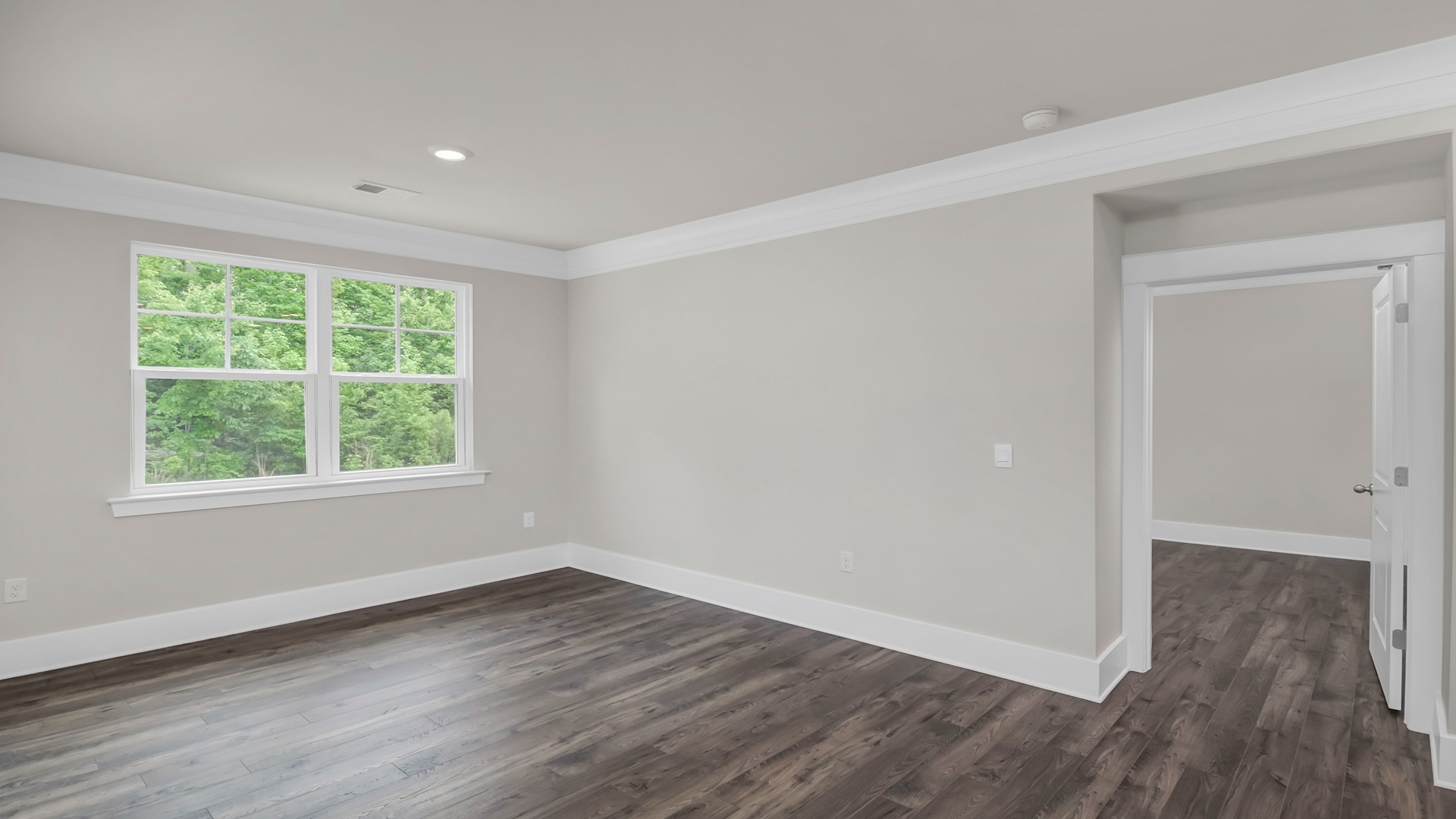 The primary bedroom features matching luxury vinyl flooring and a large window.The primary bedroom features matching luxury vinyl flooring and a large window.