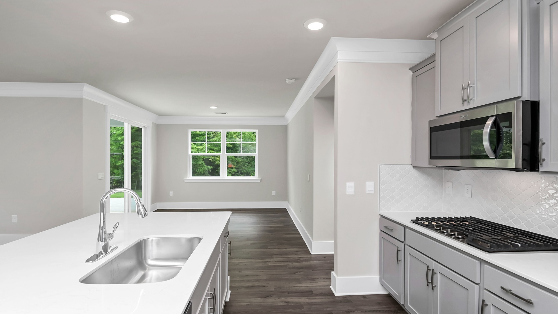 Sleek white quartz countertops finish the kitchen area.