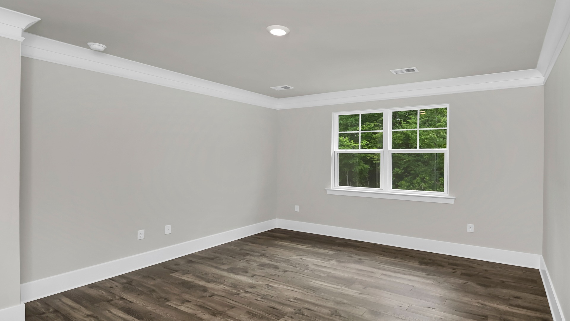 The primary bedroom features matching luxury vinyl flooring and a large window.