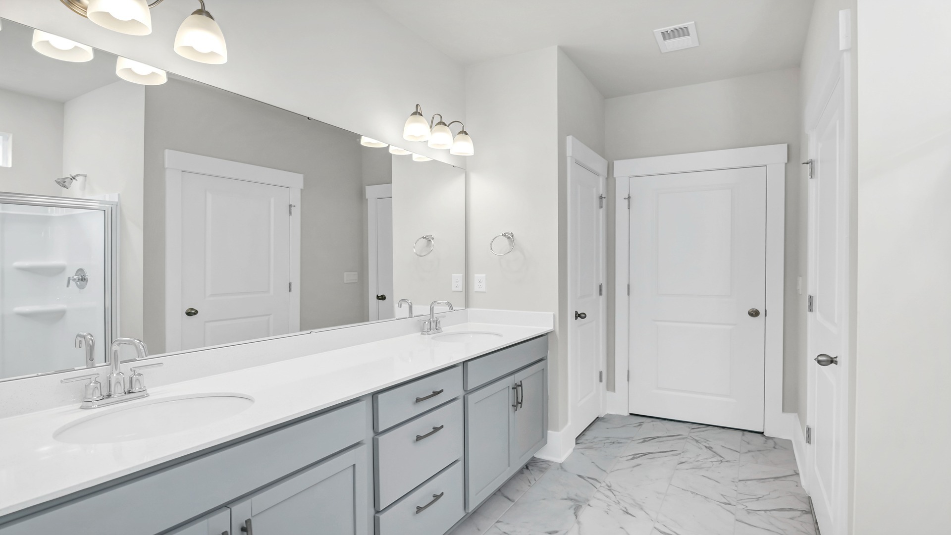 The primary bathroom features double sinks and a standup shower.