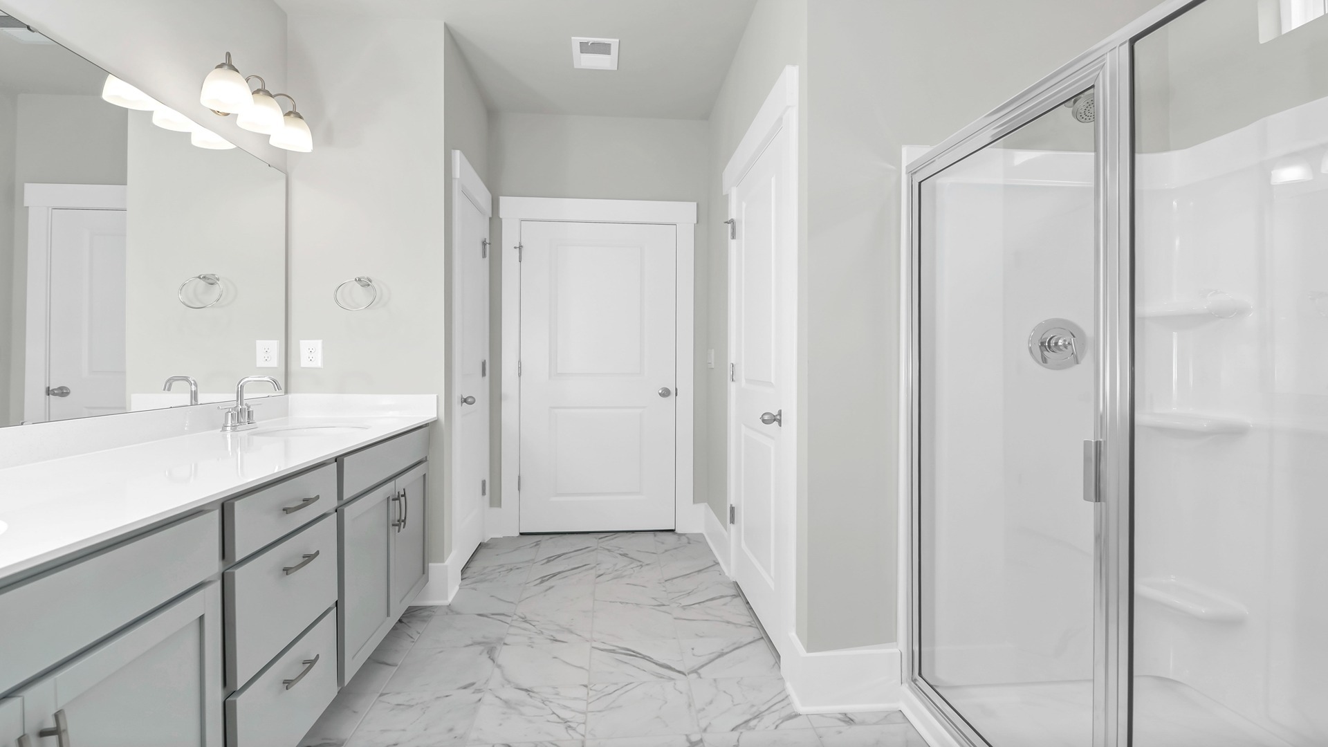 The primary bathroom features double sinks and a standup shower.