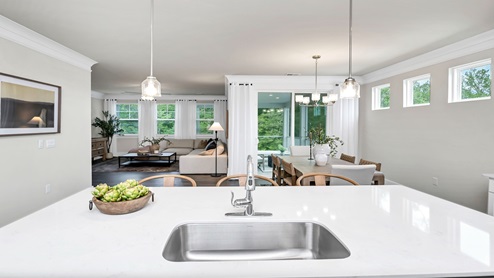The kitchen sink on the island overlooks the dining and living areas.