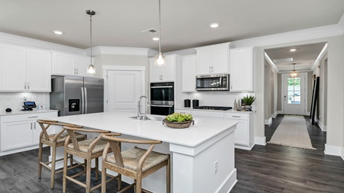 Darby kitchen off the front foyer with white quartz countertops and white cabinetry.