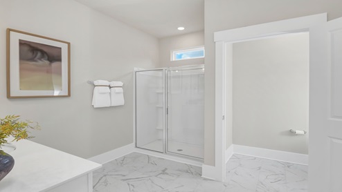 The primary bathroom is spacious with a standup shower and a separate water closet.