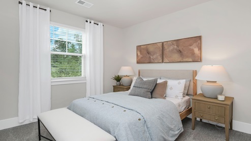 Downstairs bedroom carpeted with a window for natural light.