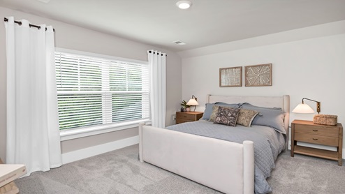 Upstairs bedroom carpeted with a large window for natural light.
