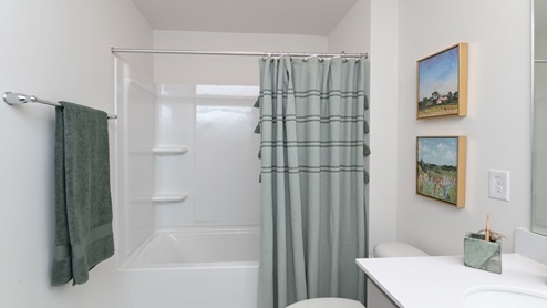 Bathroom 2 with double sinks and gray cabientry.