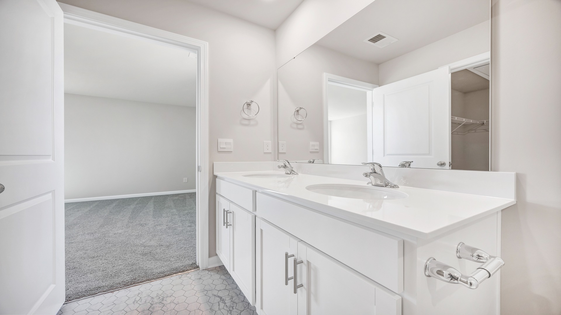 Double vanity in primary bathroom with white cabinetry