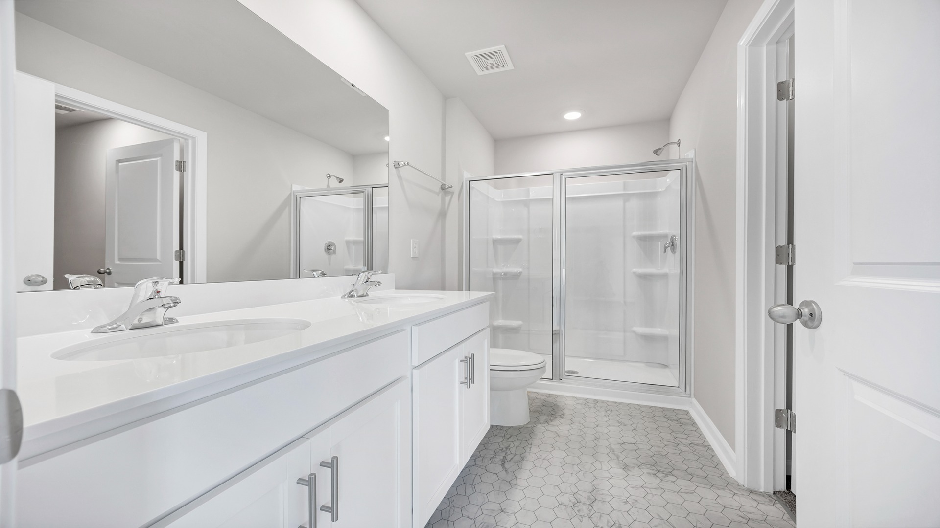 Primary bathroom with double sinks and a standup shower.