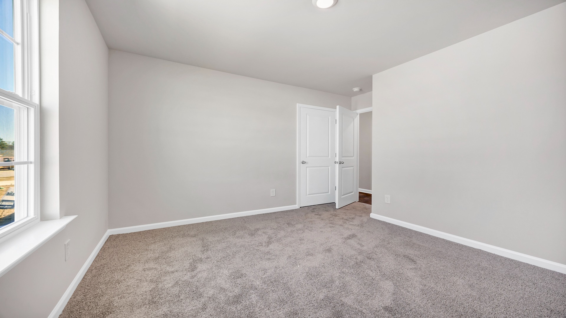 Bedroom 2 with carpet and a window for light.